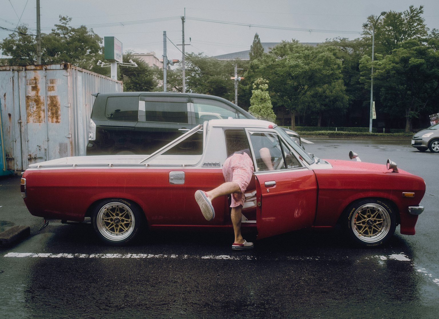 A person entering a red truck in a parking lot
