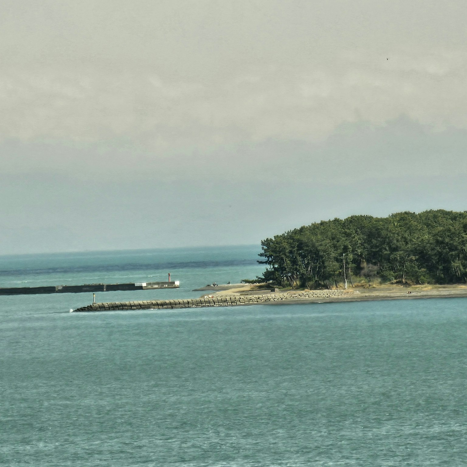Pemandangan air dan pulau dengan perahu kecil mengapung
