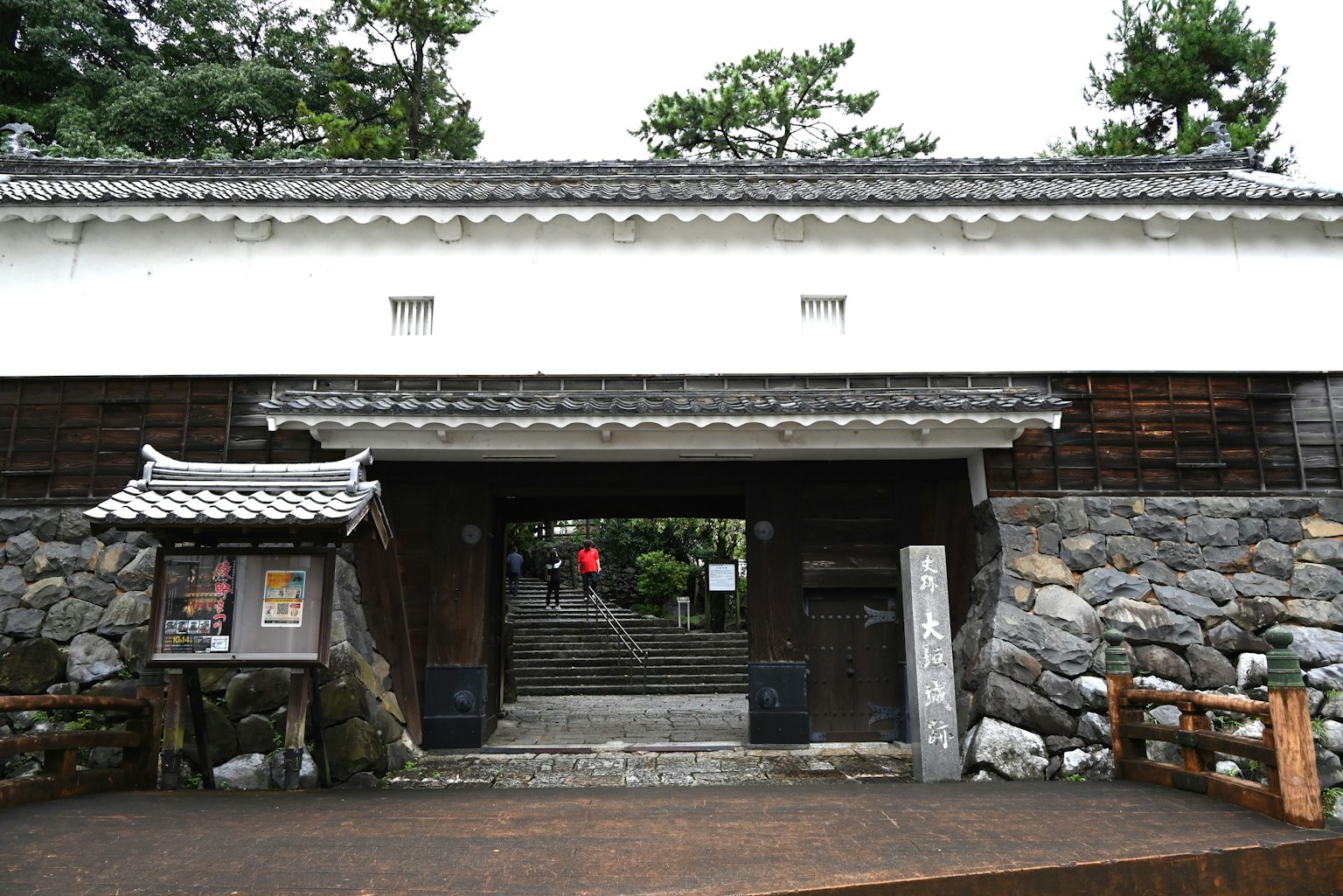 Traditional Japanese gate with stone wall and wooden details