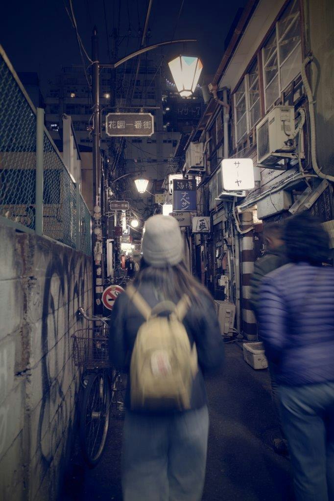 nighttime narrow shopping alley with people walking