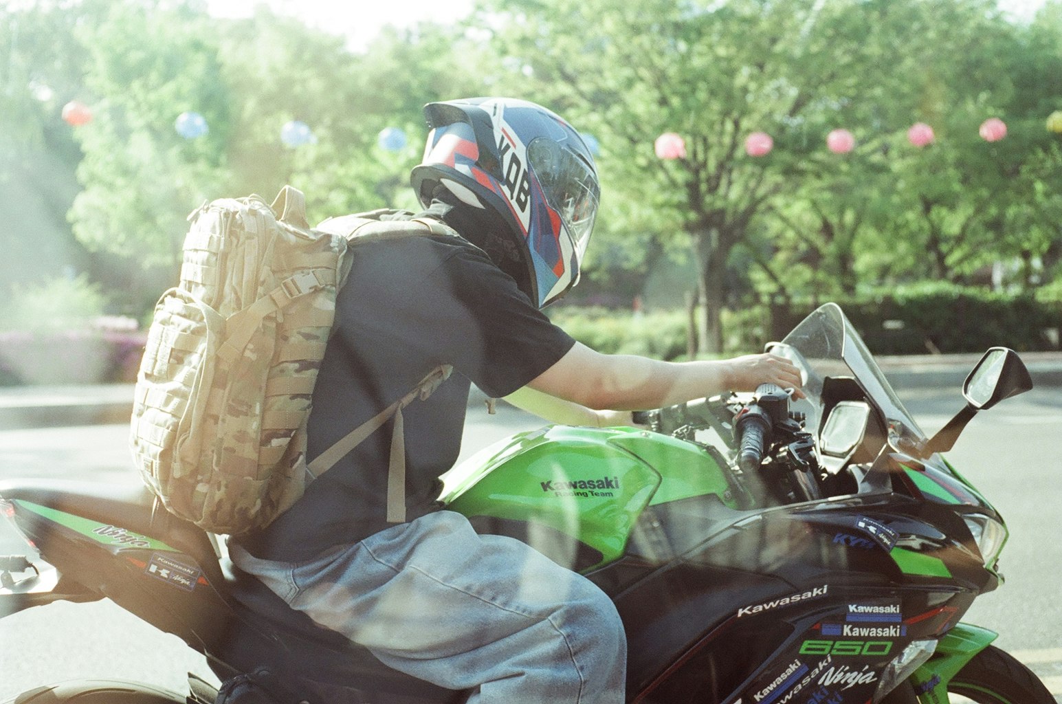 緑のバイクにまたがるライダーとヘルメット