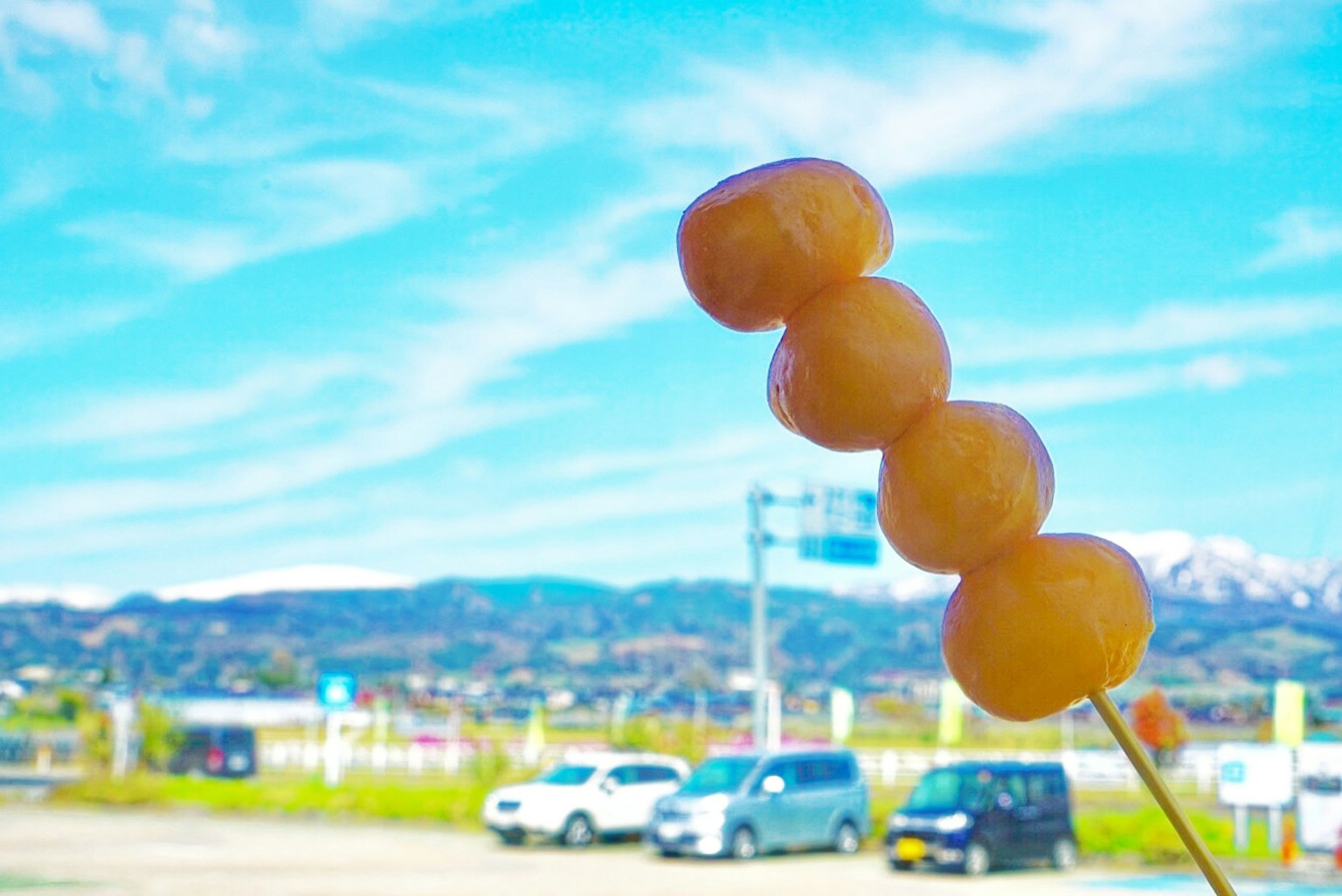 Photo de brochettes de dango sous un ciel bleu