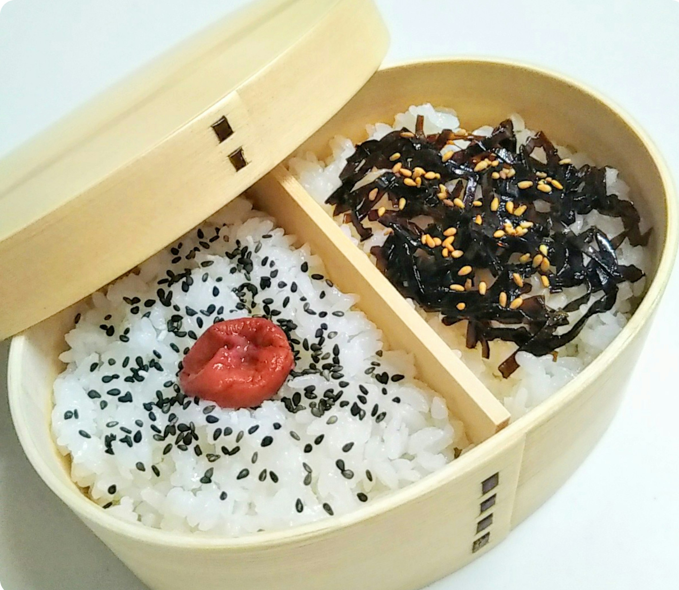 木製弁当箱に盛られた白ご飯と梅干しと海苔の佃煮