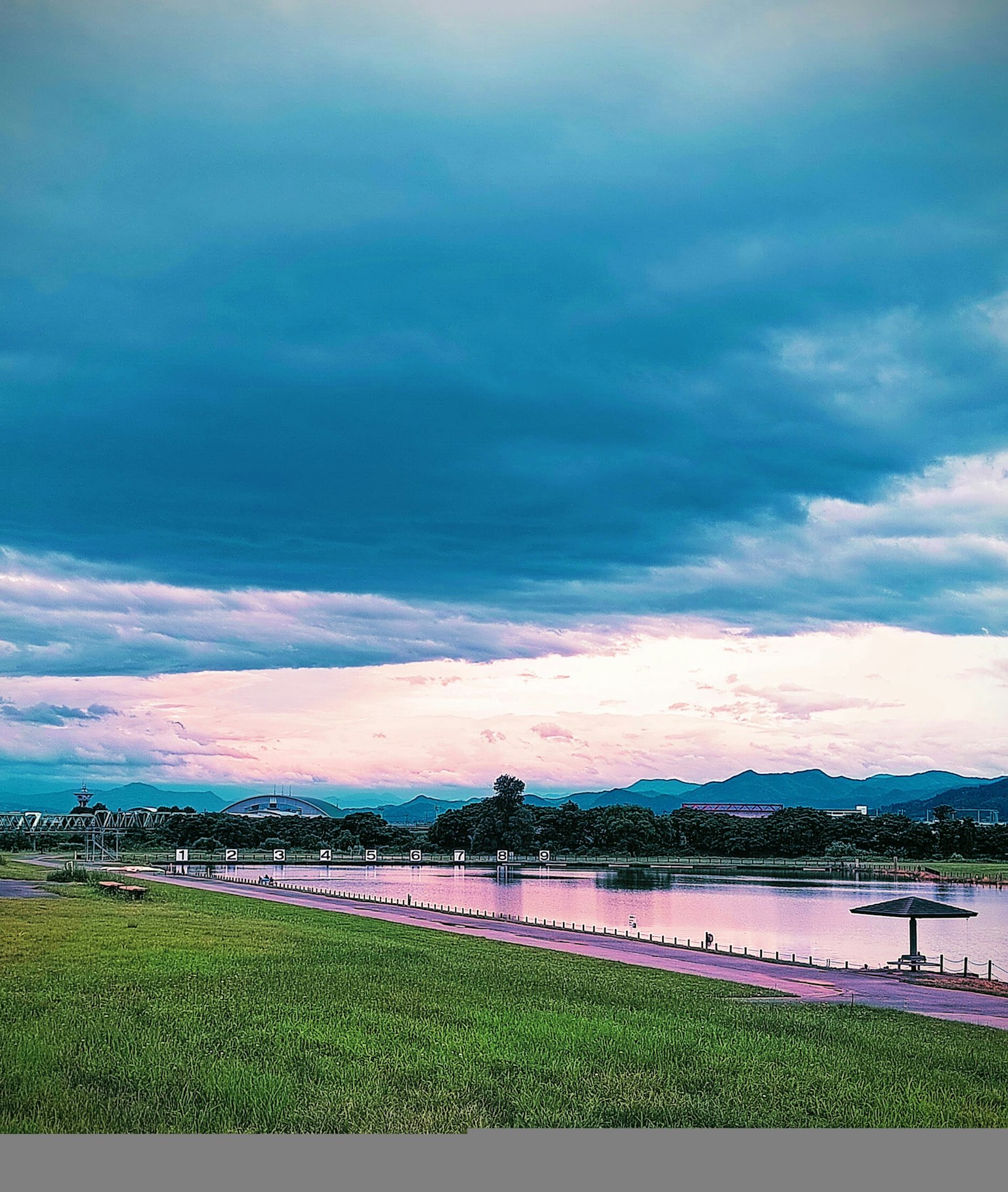 傍晚河岸风景蓝天和云朵绿色草地和宁静水面