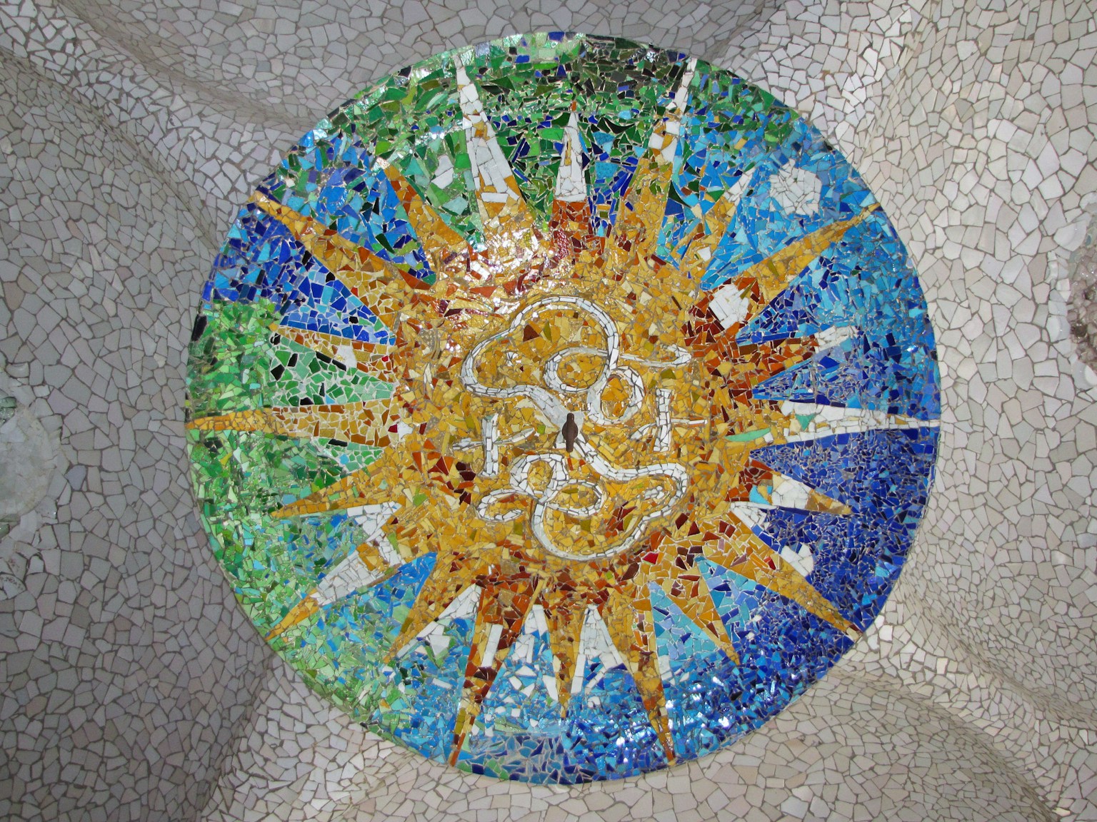 カラフルなモザイクの太陽模様が描かれた円形のタイル
