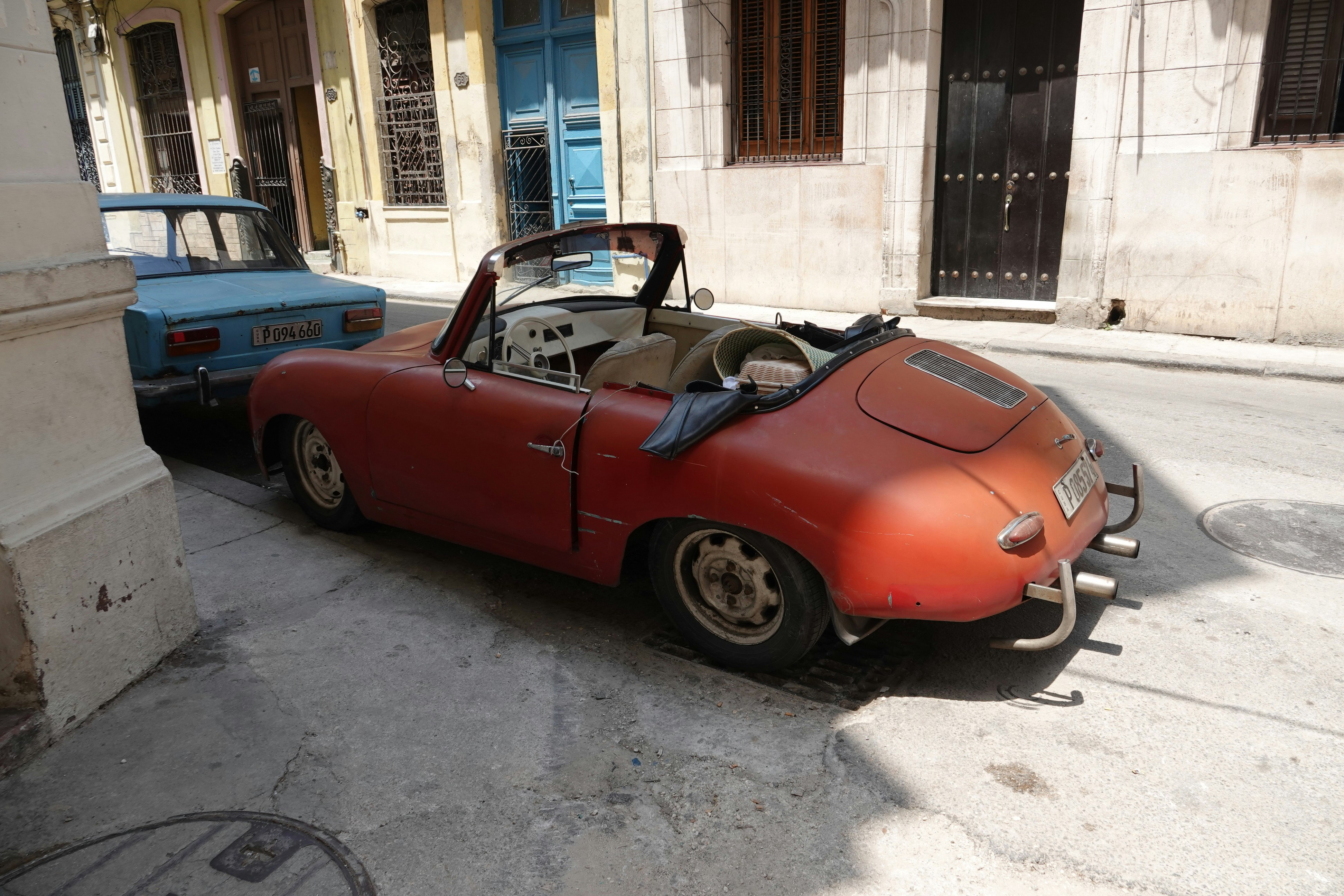路地に停まるクラシックなオレンジ色のオープンカー