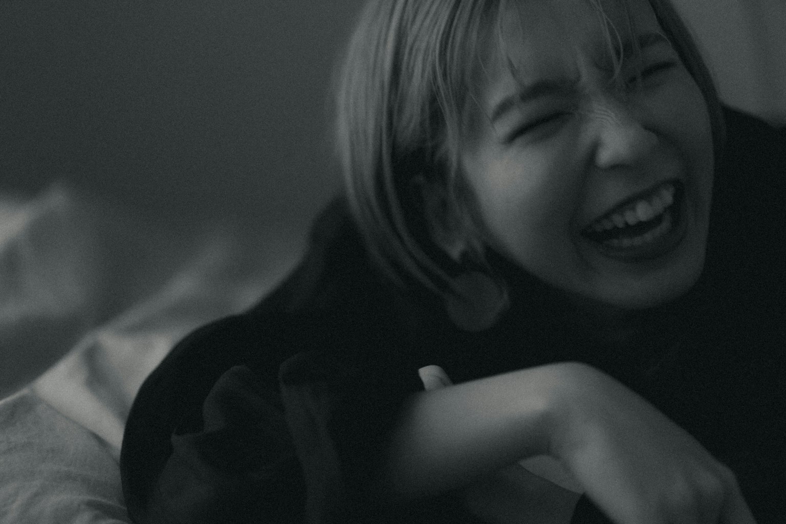 Una foto en blanco y negro de una mujer riendo alegremente