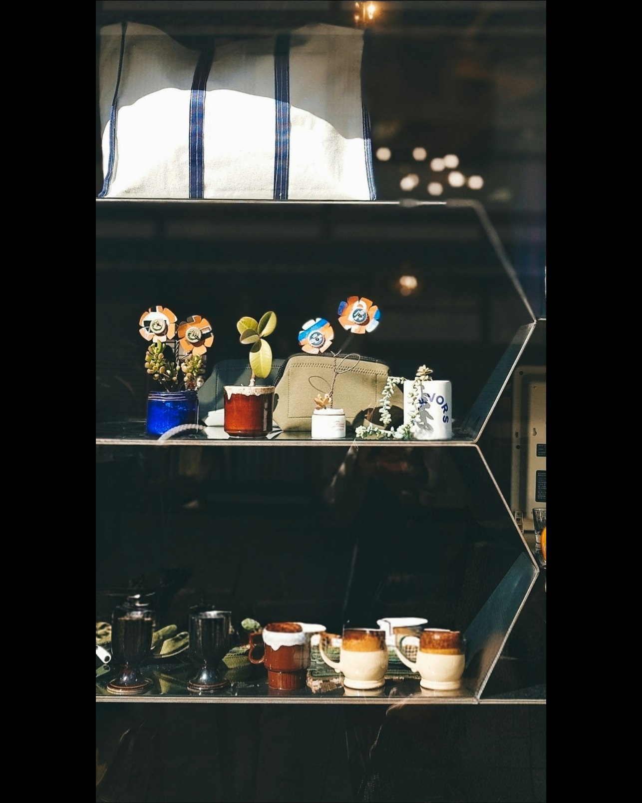 棚に並ぶ観葉植物と雑貨のあるカフェの店内