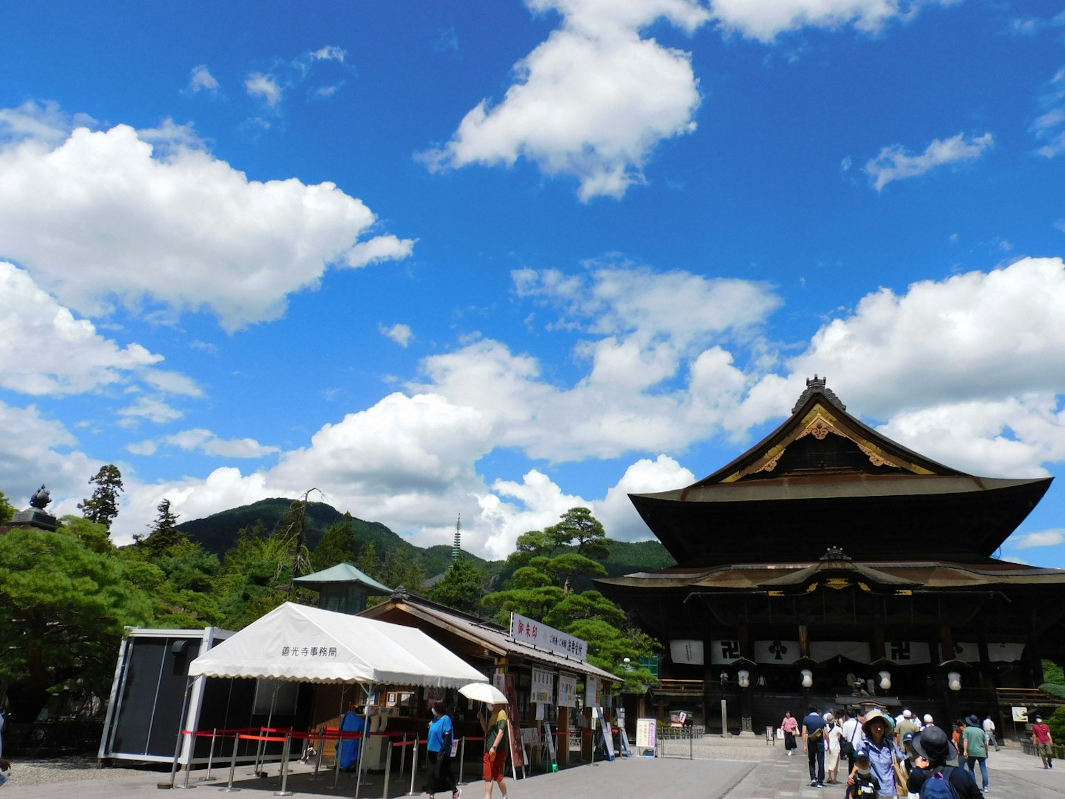 Beautiful Japanese temple under a blue sky with clouds and visitors