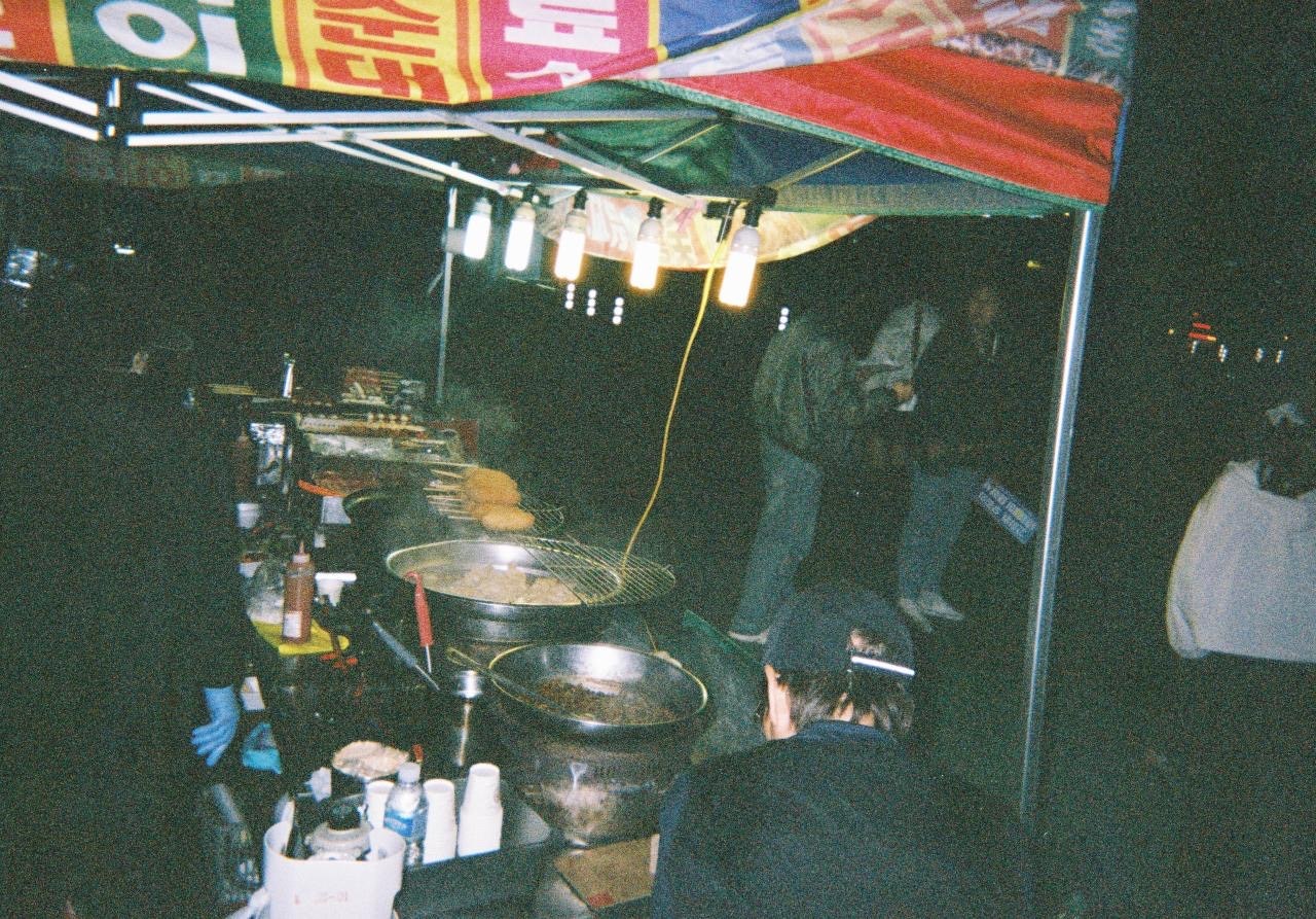 屋台の調理器具と鍋が並ぶ夜の店先
