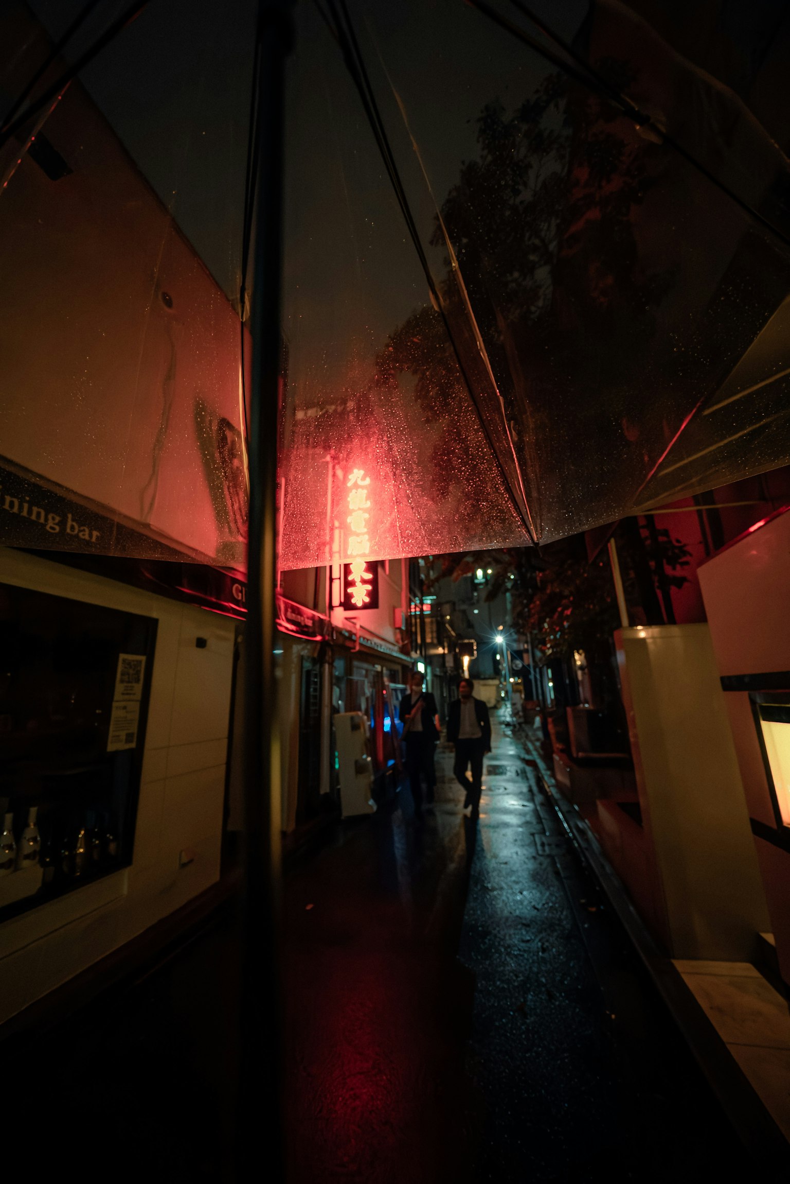 雨夜昏暗街道上的红色霓虹灯招牌