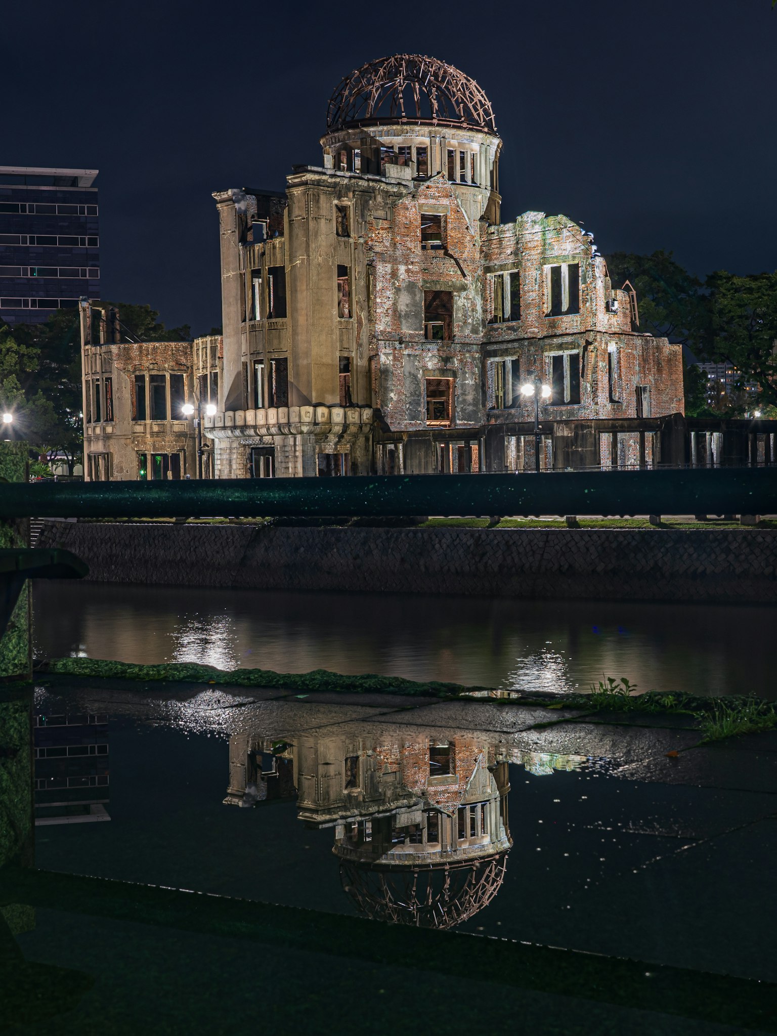 Bella esterno del Museo memoriale della pace di Hiroshima di notte con riflesso sull'acqua