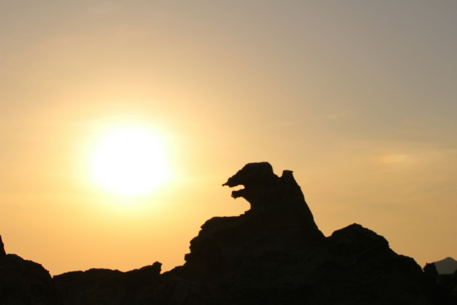 Silhouette eines Felsens, der einem Tier gegen den Sonnenuntergang ähnelt