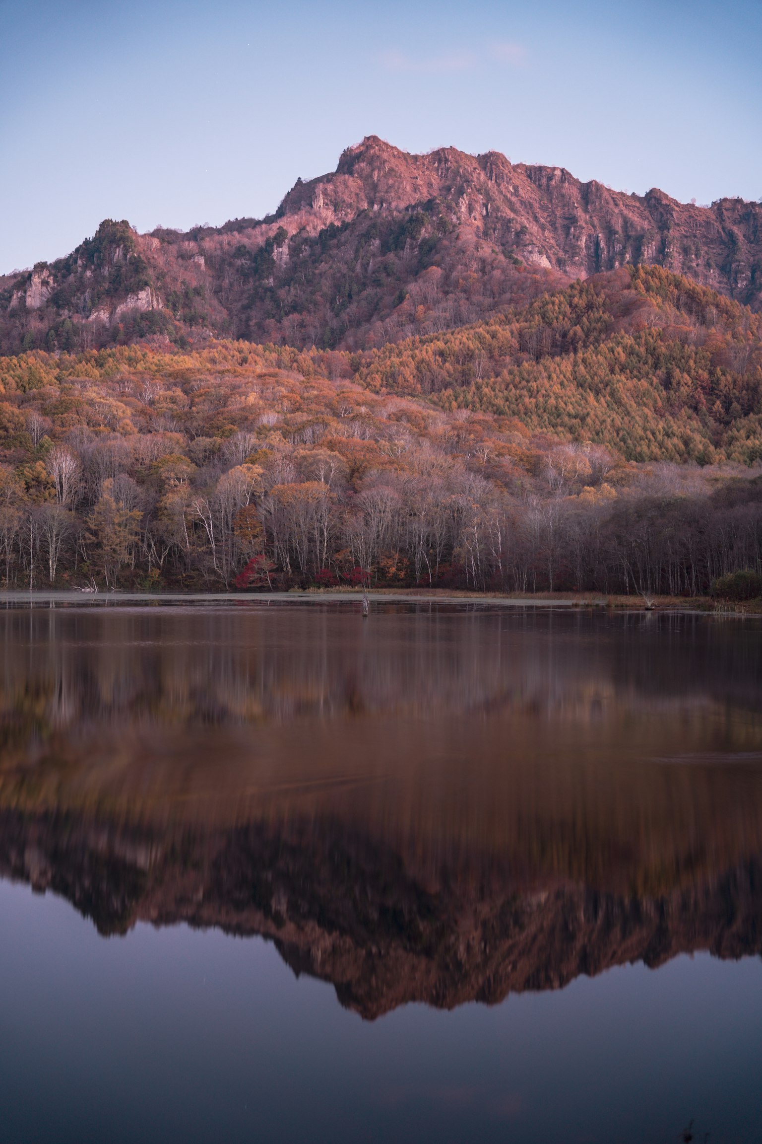 秋天色彩斑斕的山脈在平靜的湖面上反射的風景
