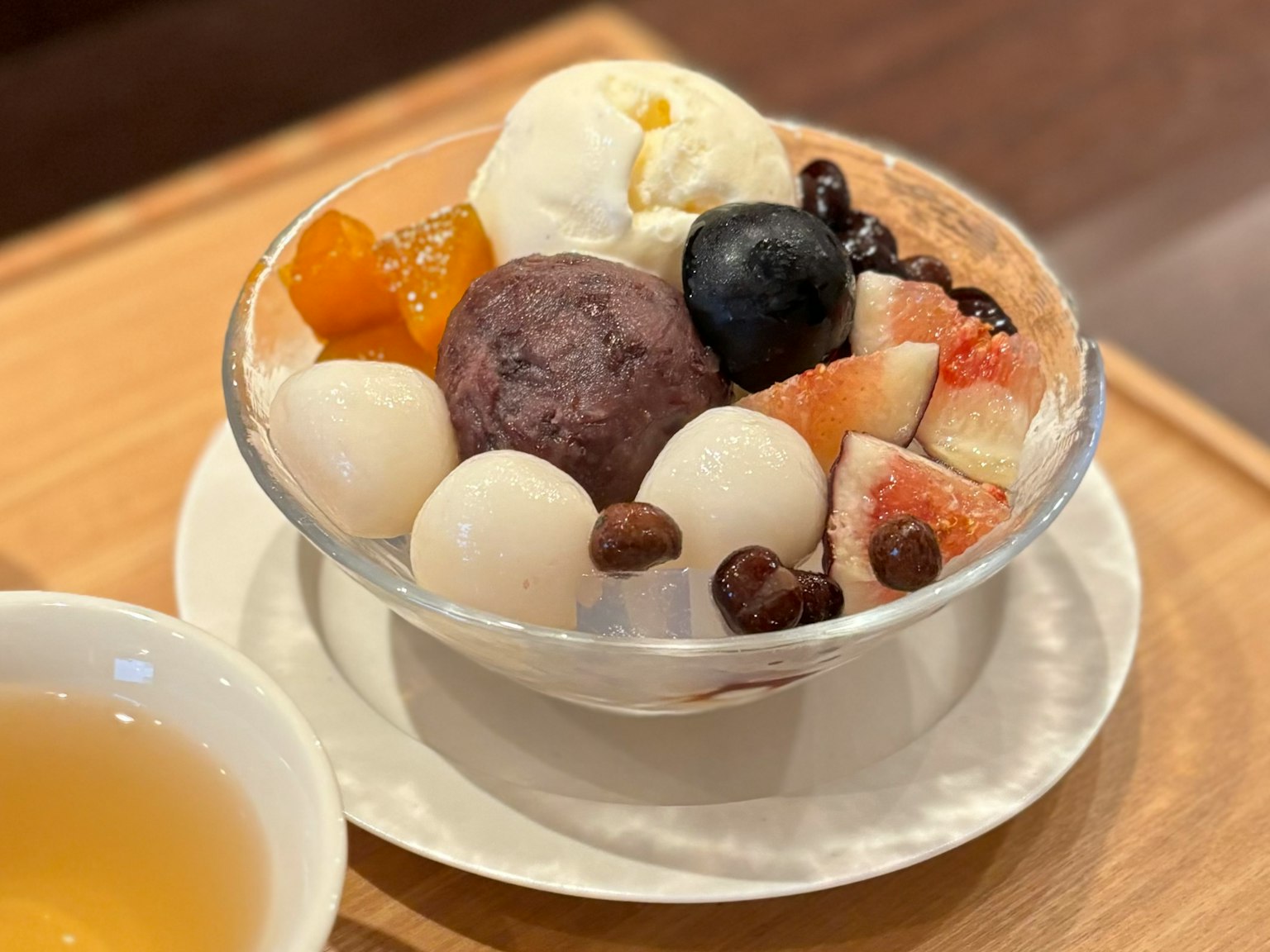 水果和冰淇淋的甜點碗旁邊有茶