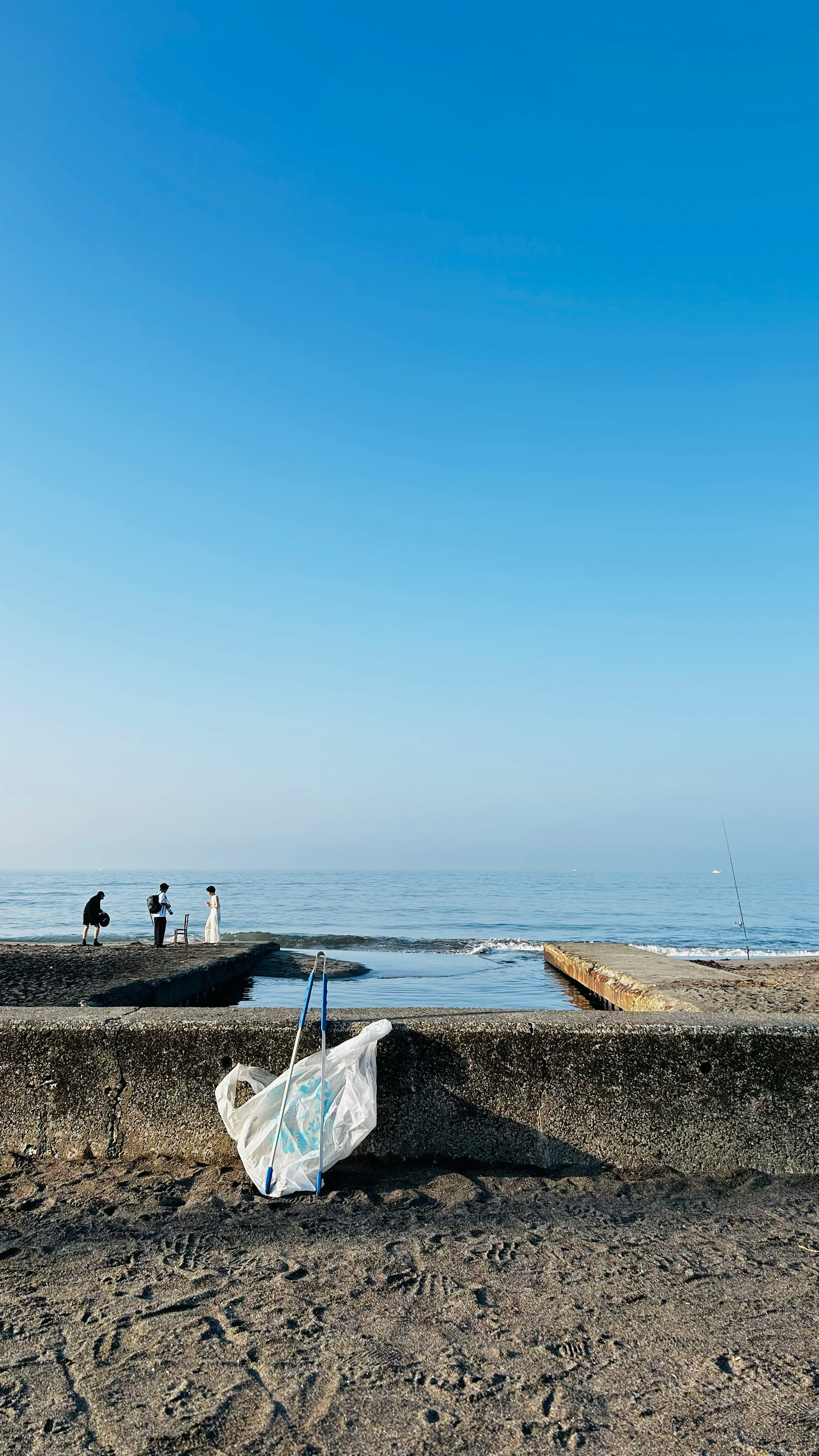seaside breakwater and sandy beach with a plastic bag