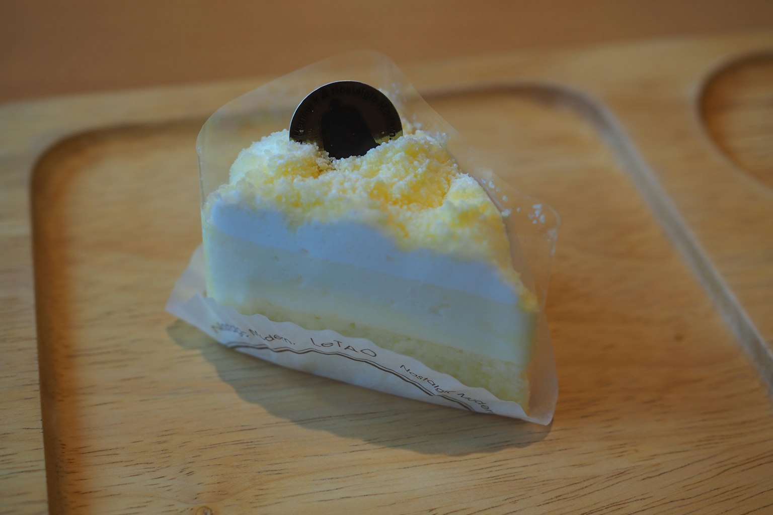 Tranche de gâteau avec un topping en chocolat noir et des couches de crème et jaune visibles