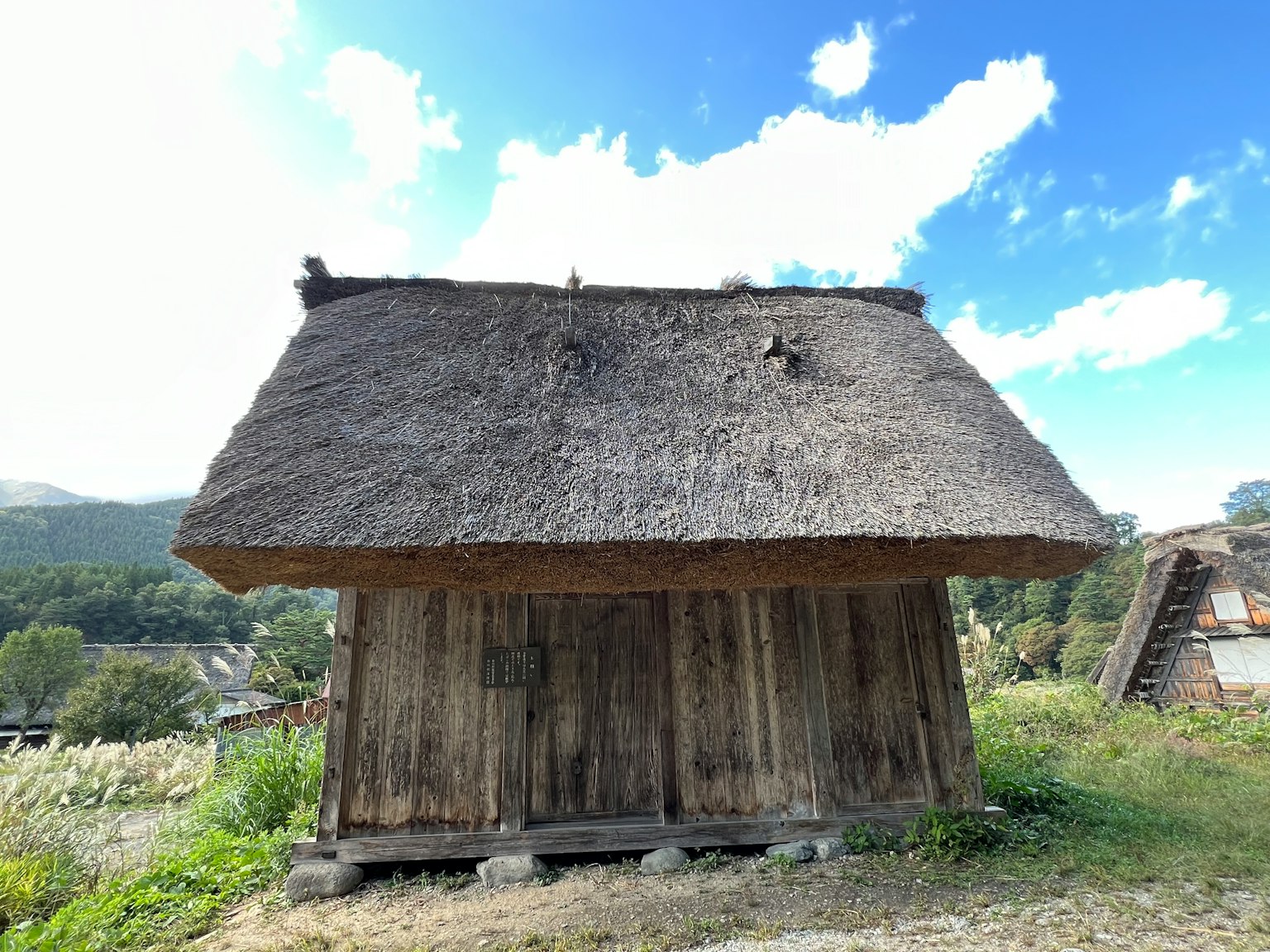 Gubuk kayu atap jerami di bawah langit biru