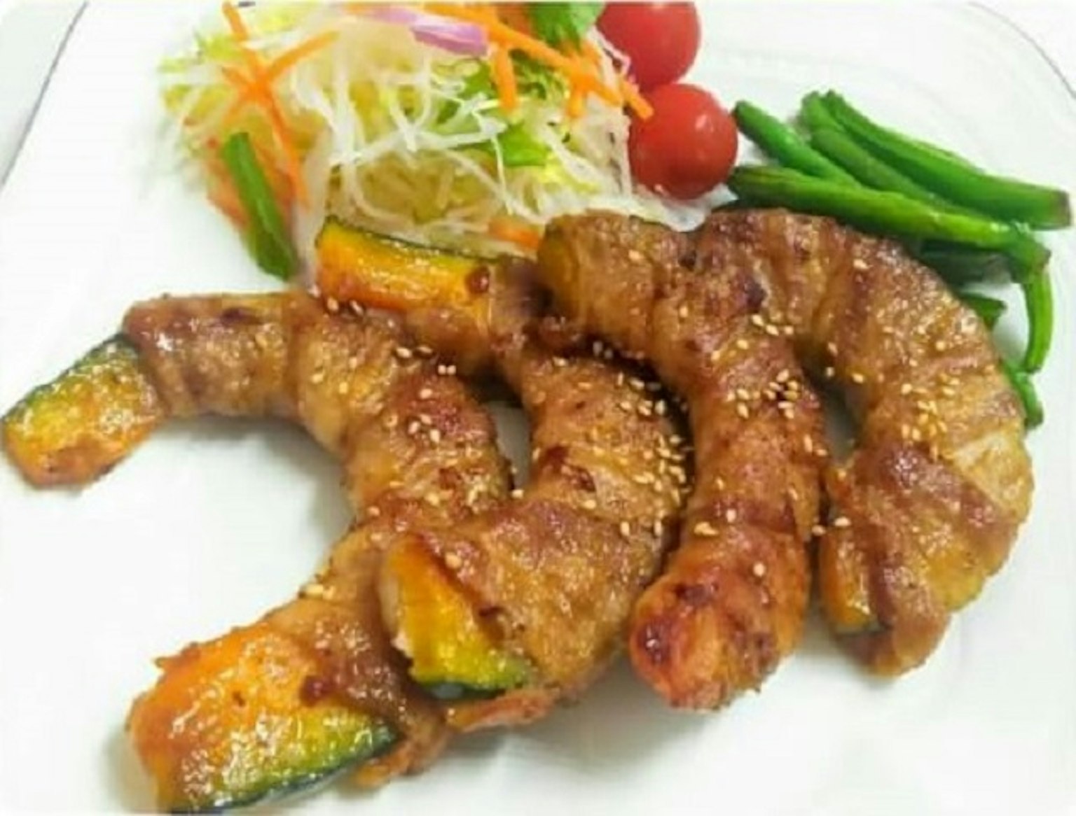 Đĩa với những cuộn thịt ngon và rau củ có hạt mè