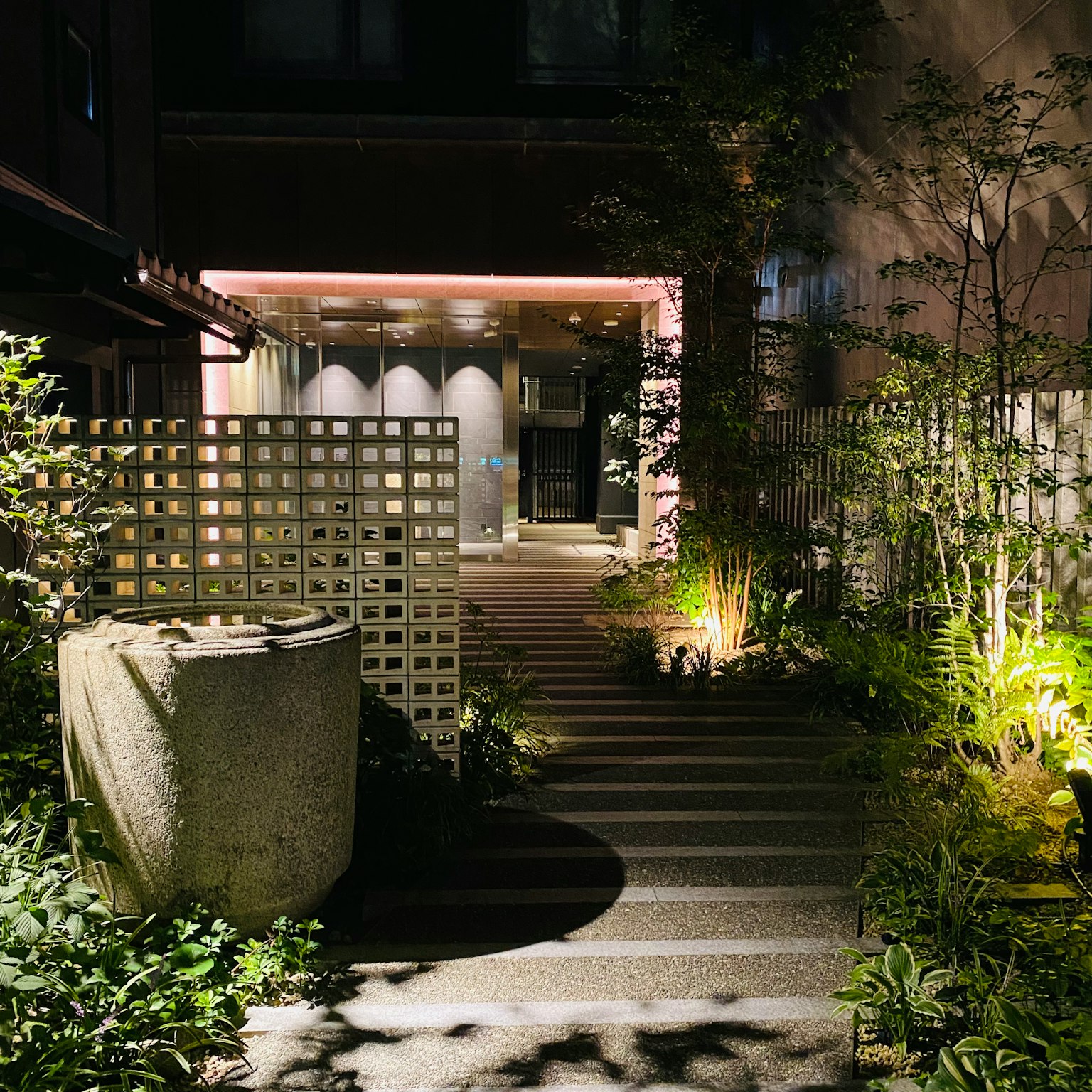 Entrata con scalini in pietra che conducono a un giardino di notte