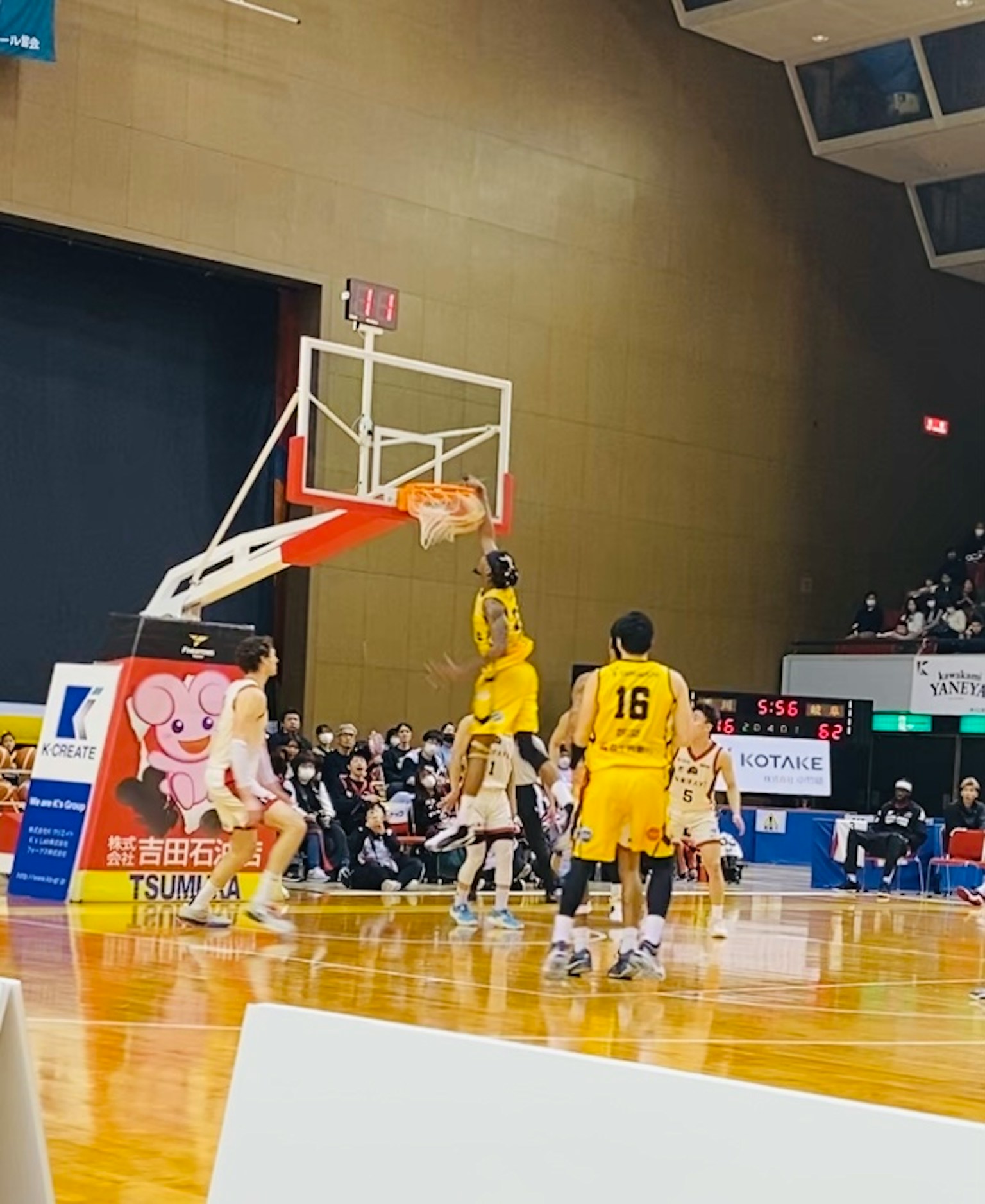 A basketball player performing a dunk during a game