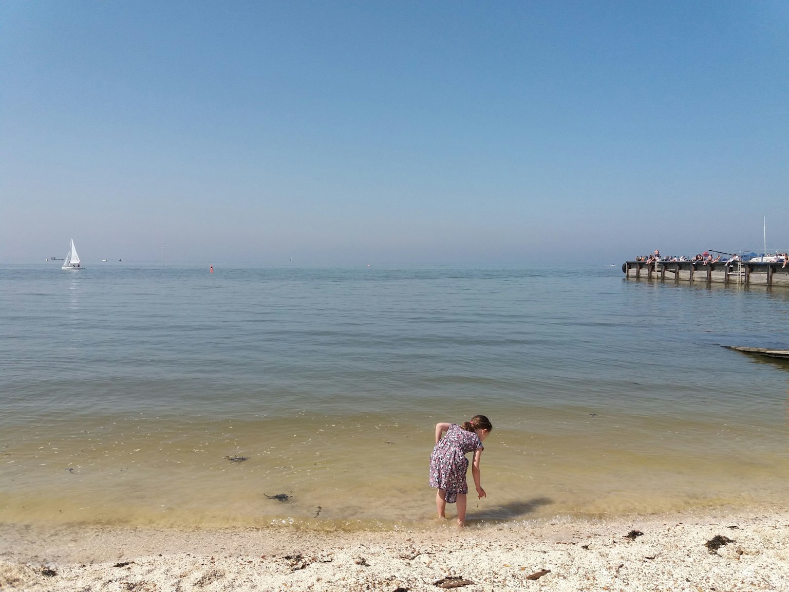 孩子在安静的海滩上玩耍与平静的海洋