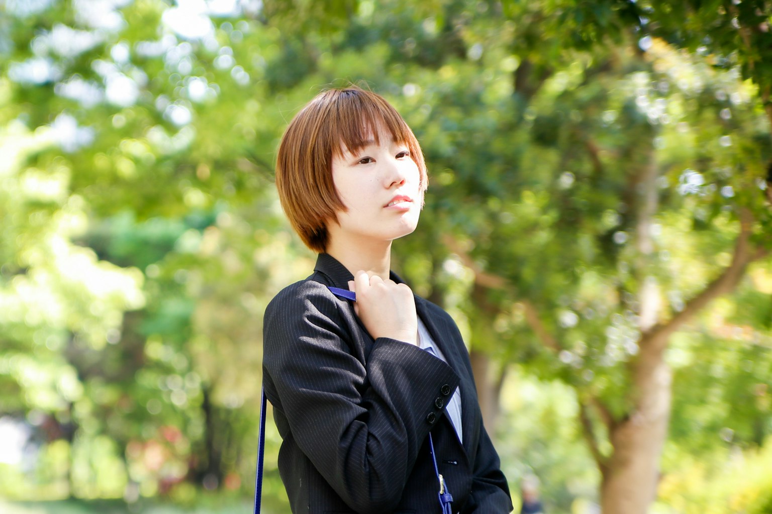 หญิงสาวคิดอยู่ในสวนที่มีพื้นหลังสีเขียวชอุ่ม