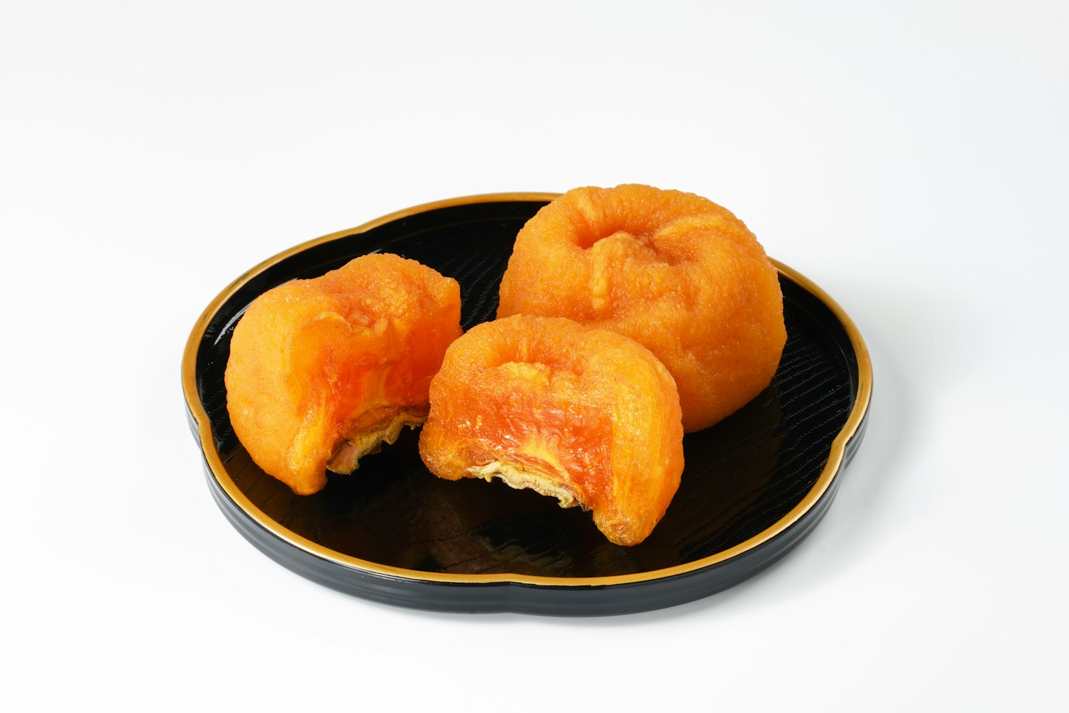 橙色糕點放在黑色盤子上