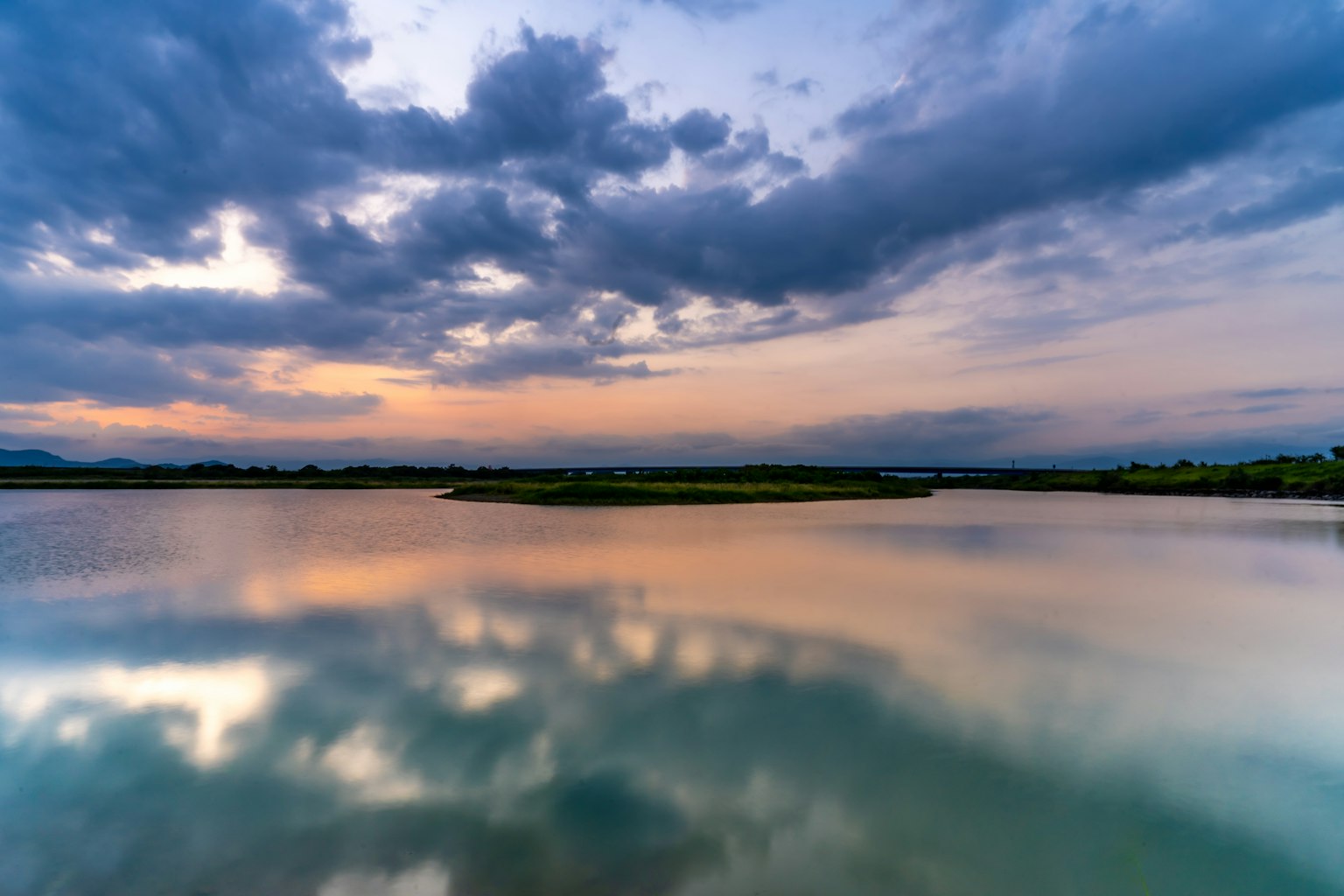 Serene landscape with clouds and sunset reflections on calm water