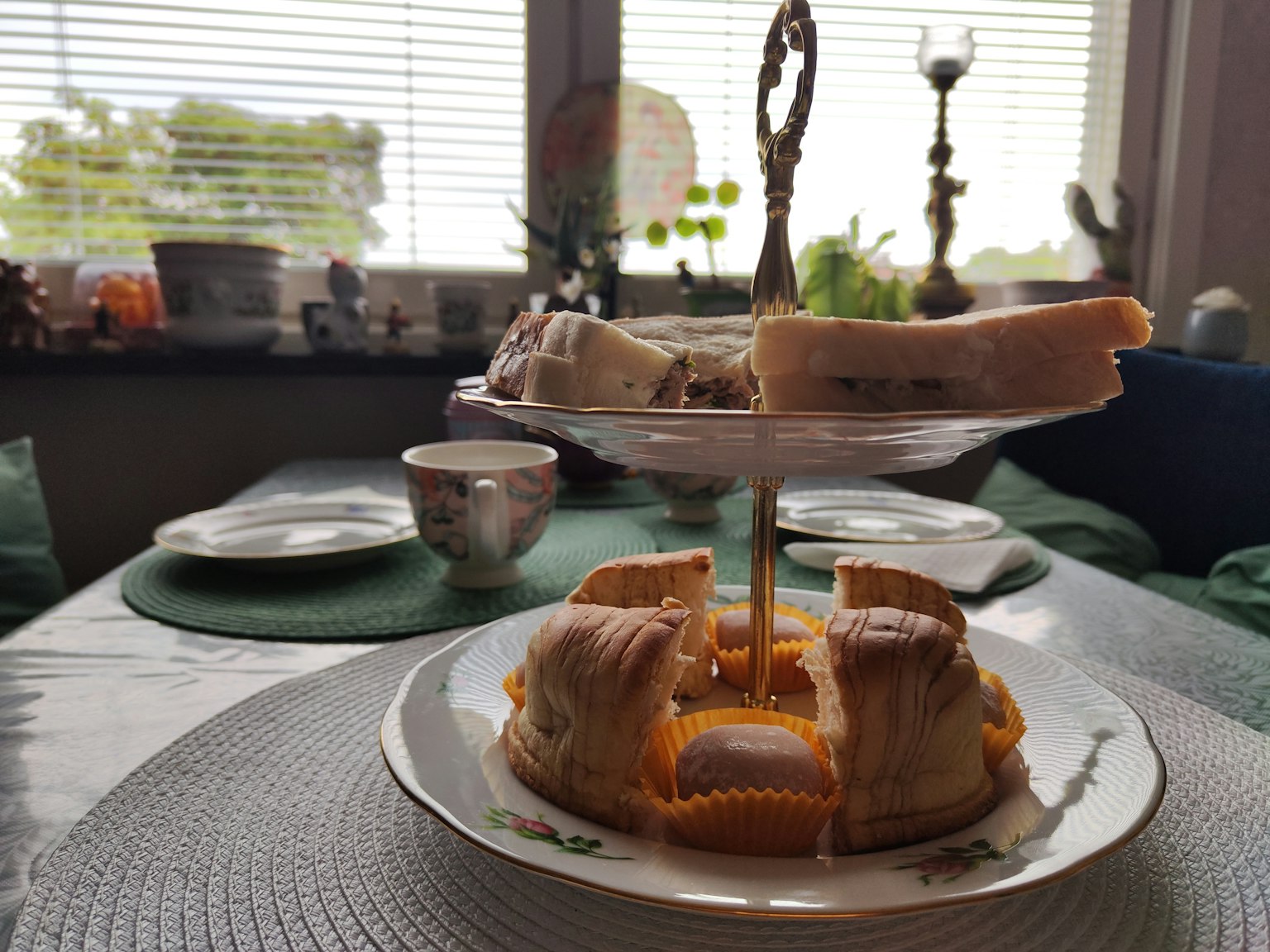 Presentasi makanan penutup yang elegan di atas rak kue dua tingkat dengan berbagai makanan manis