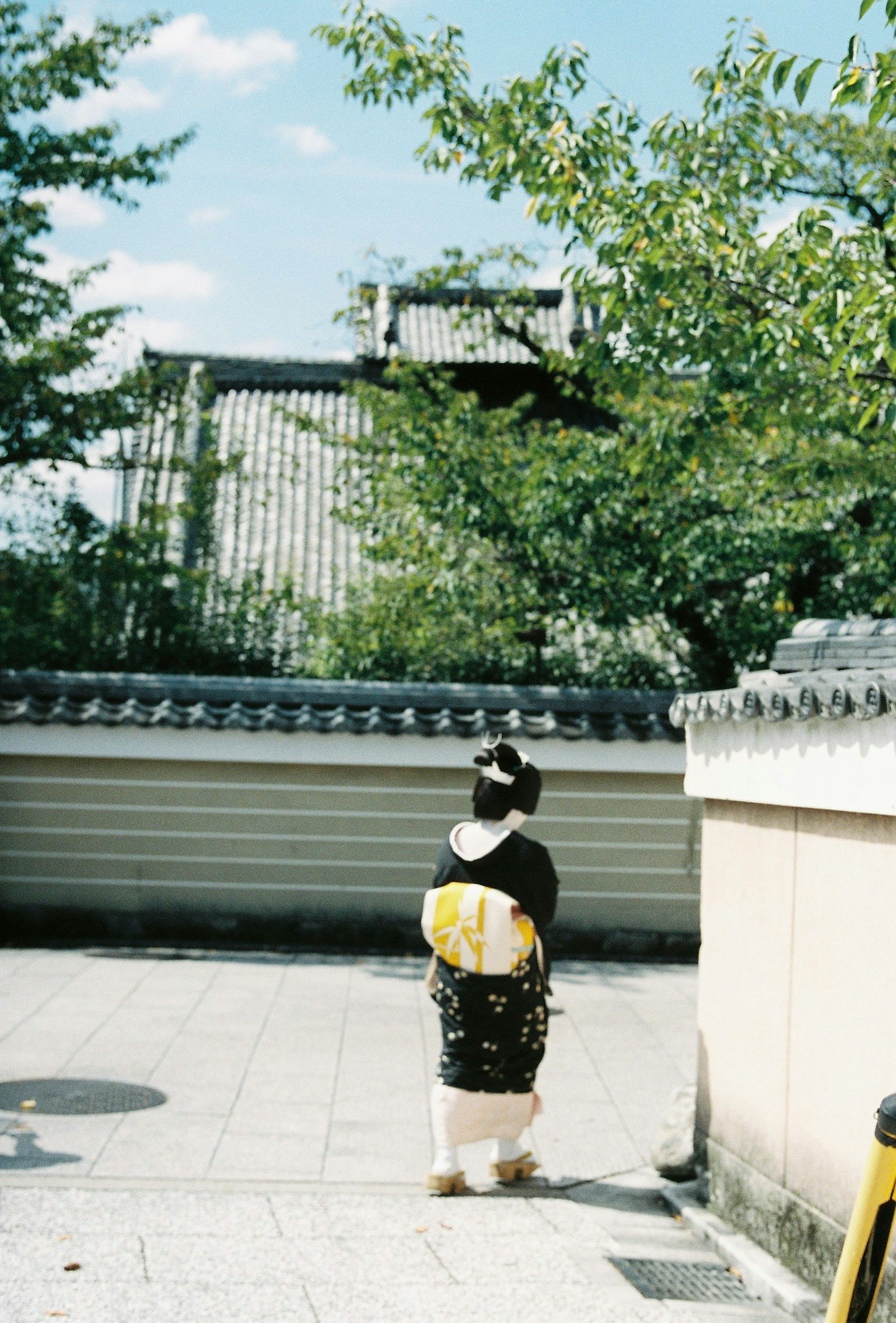 Một người phụ nữ trong trang phục kimono truyền thống đi bộ trong một khu vườn yên tĩnh