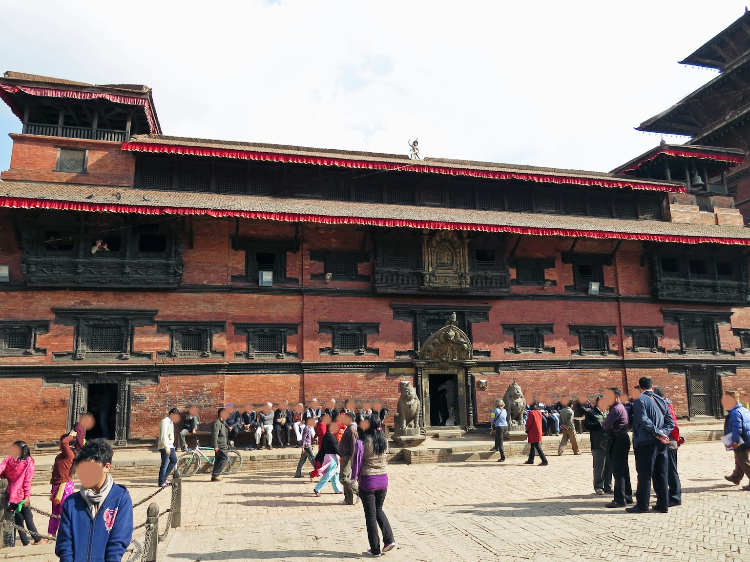 Orang-orang berkumpul di depan bangunan kuno di Lapangan Durbar Kathmandu