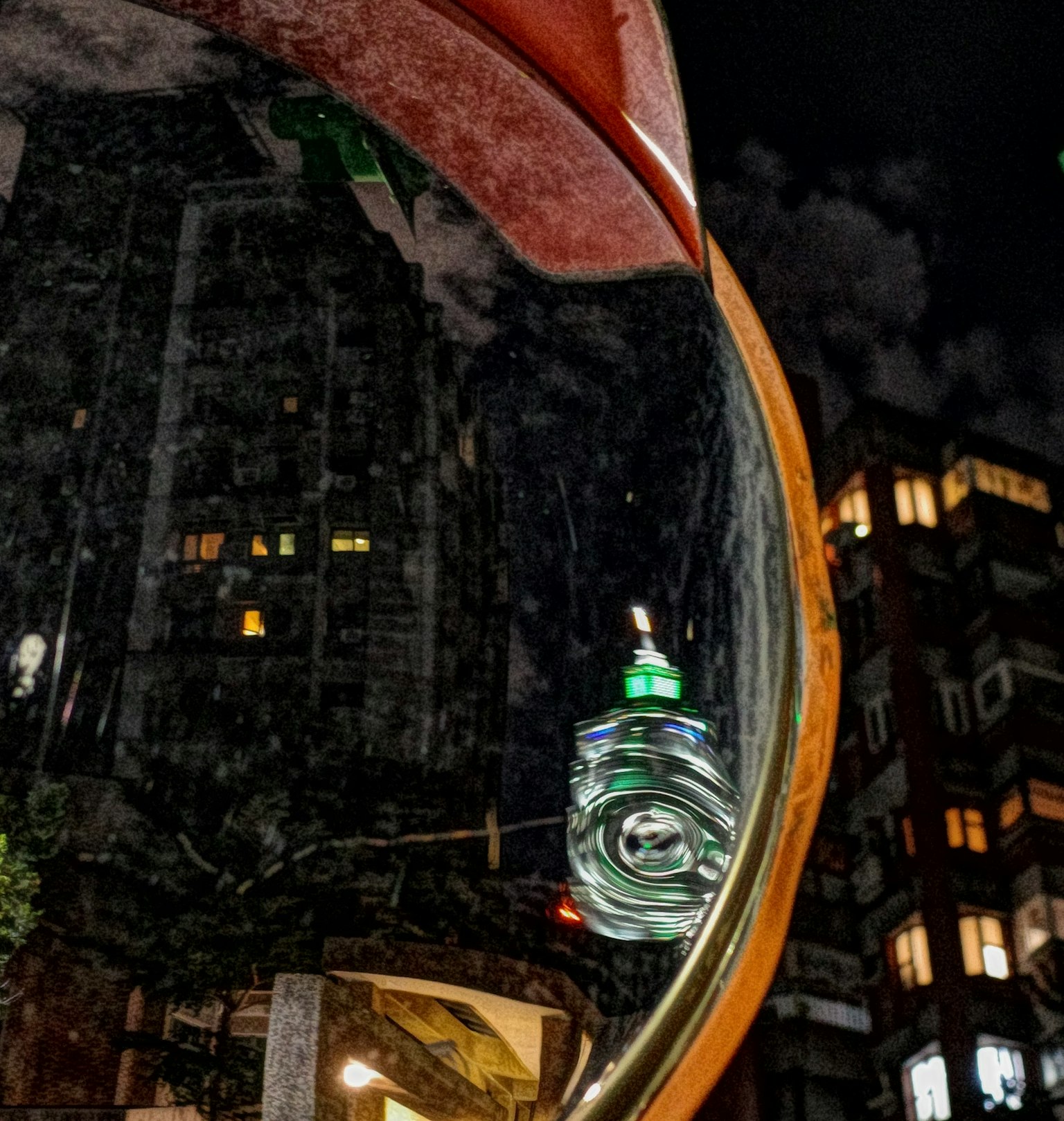 Reflexion der Stadtlandschaft in einem runden Spiegel bei Nacht