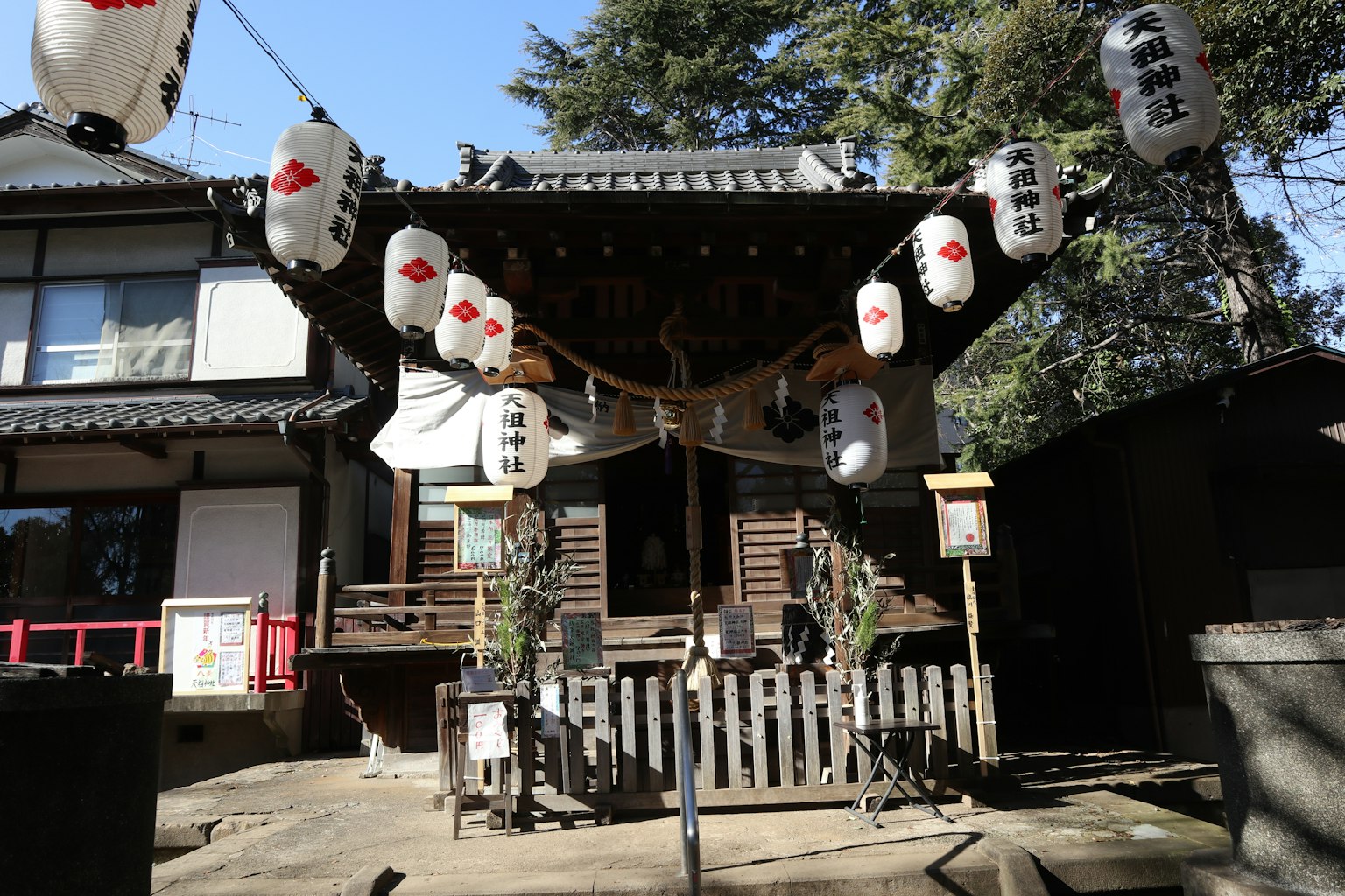 Entrance of a shrine with hanging lanterns and wooden structure