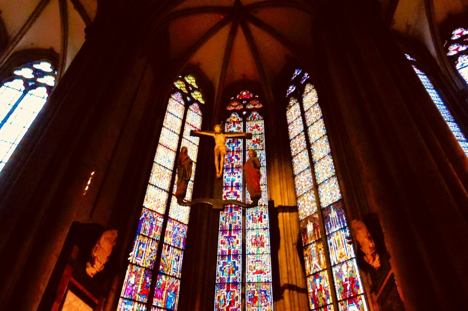 Interno di una chiesa con splendidi vetri colorati e un crocifisso