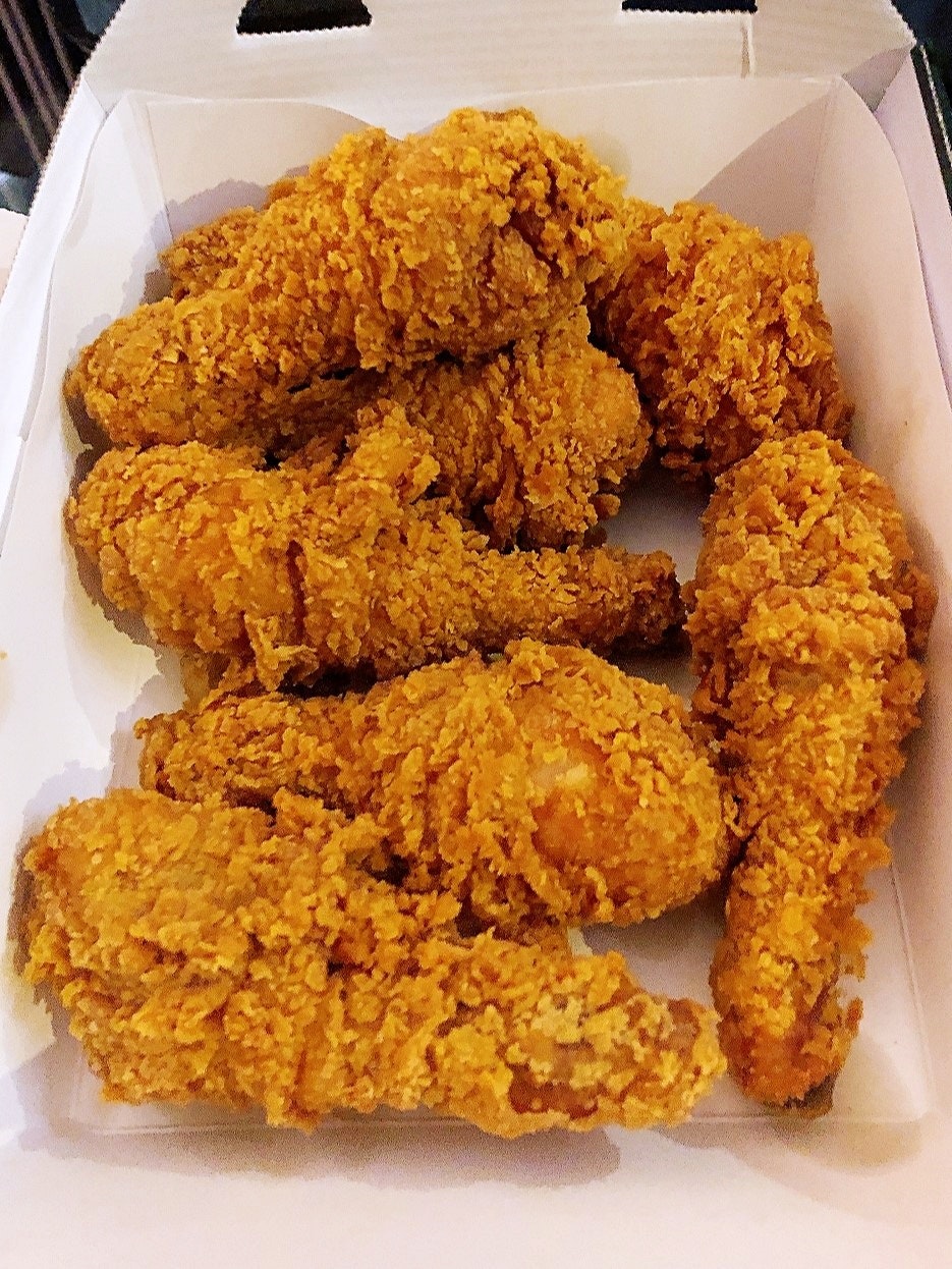 黄金色のフライドチキンが紙箱に盛られた