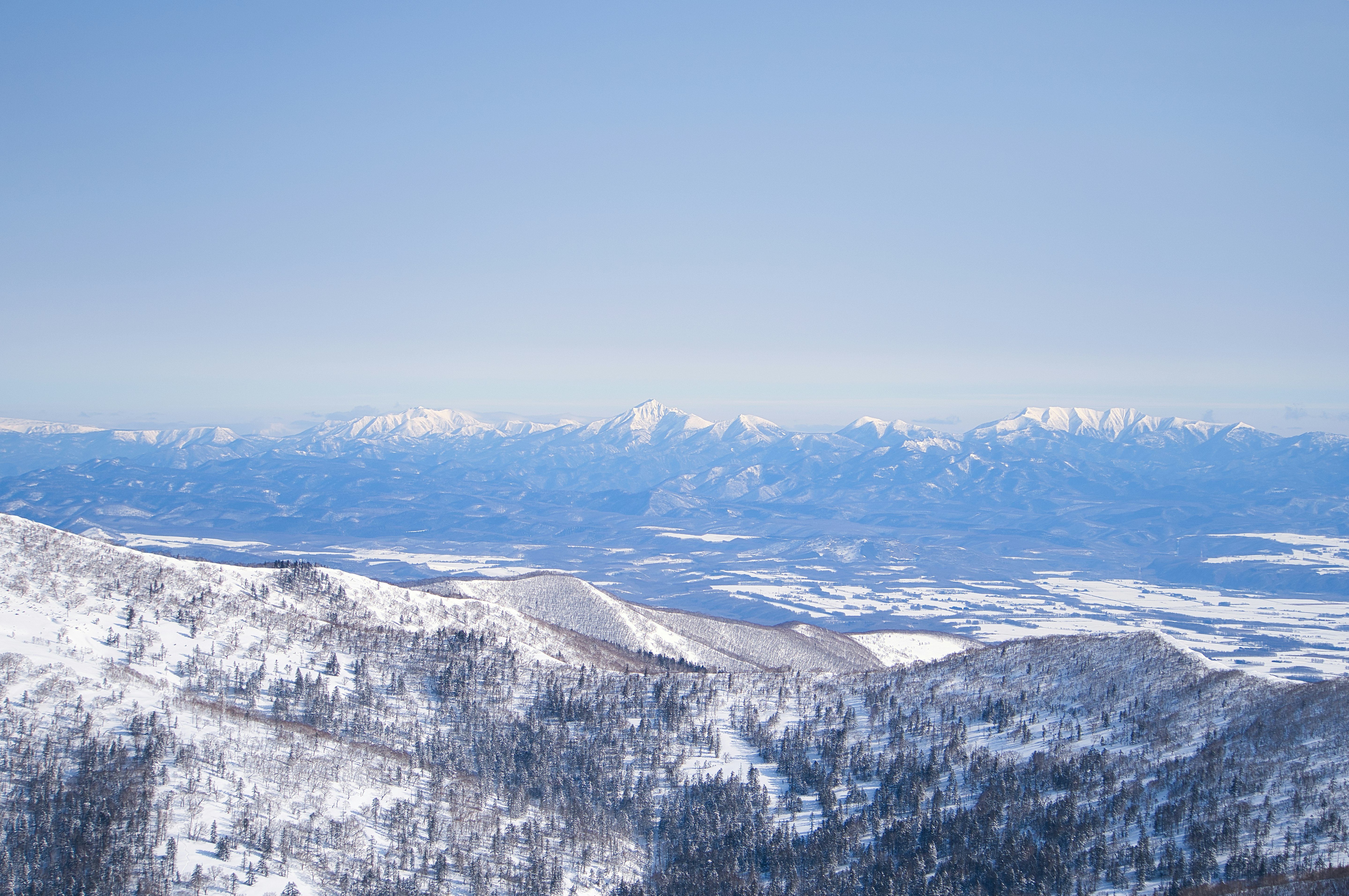 Paisaje de montañas nevadas y vasto cielo sobre la llanura de Tokachi