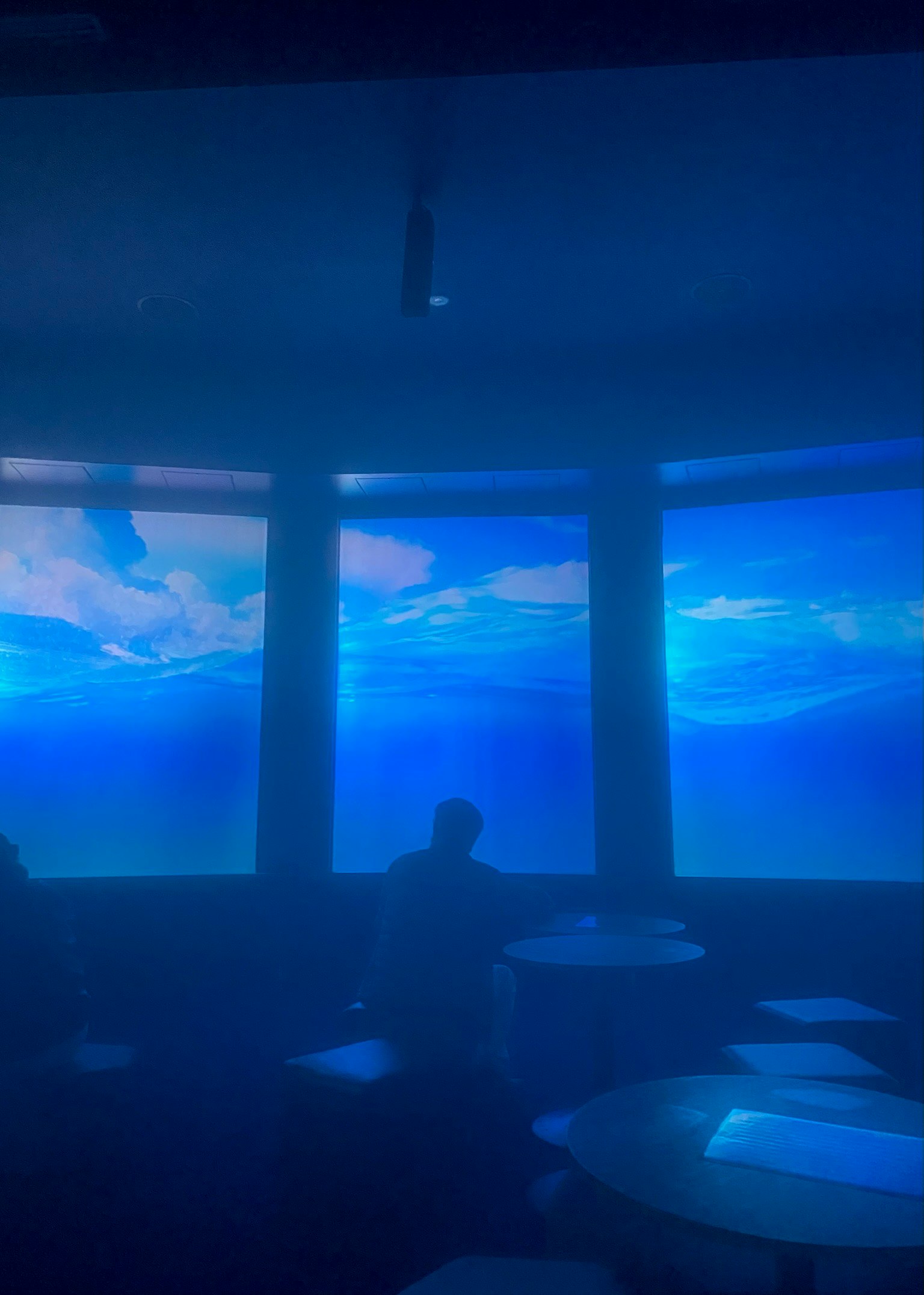 interior iluminado en azul con vista nocturna a través de grandes ventanas