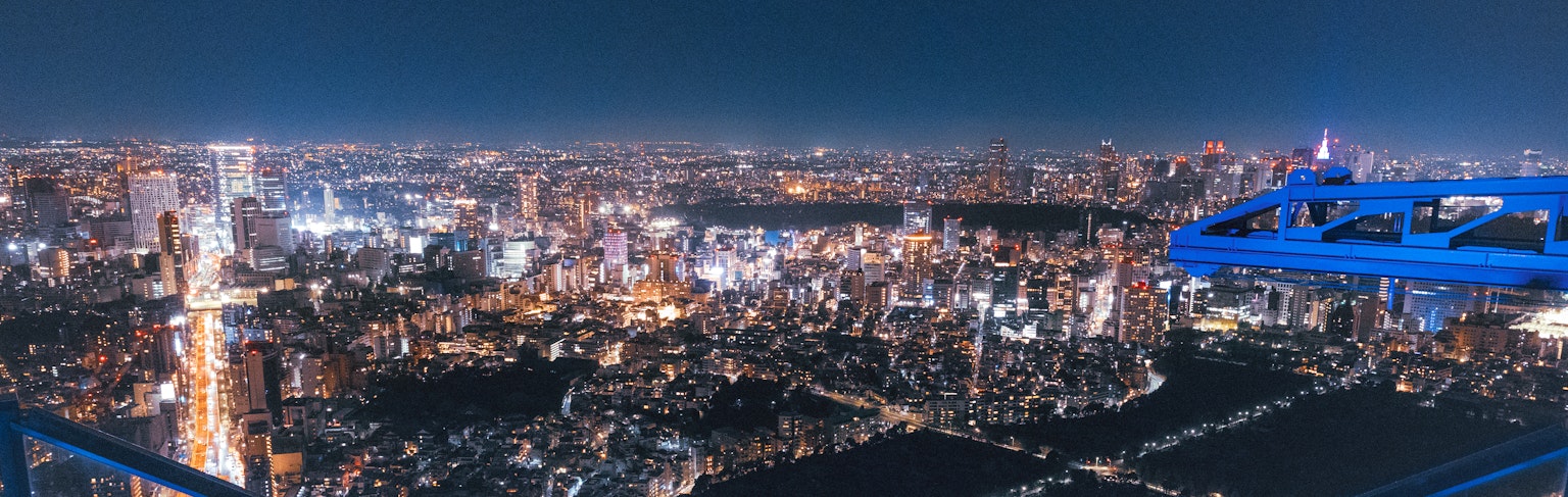 Vista panoramica di Tokyo di notte con grattacieli e luci brillanti della città