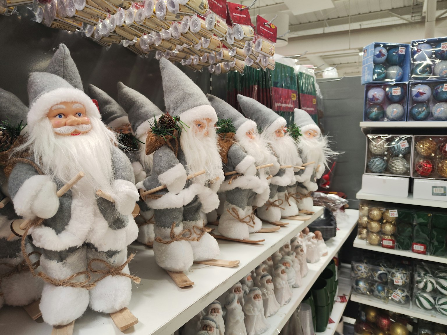 Figurine di Babbo Natale con cappelli grigi esposte su uno scaffale