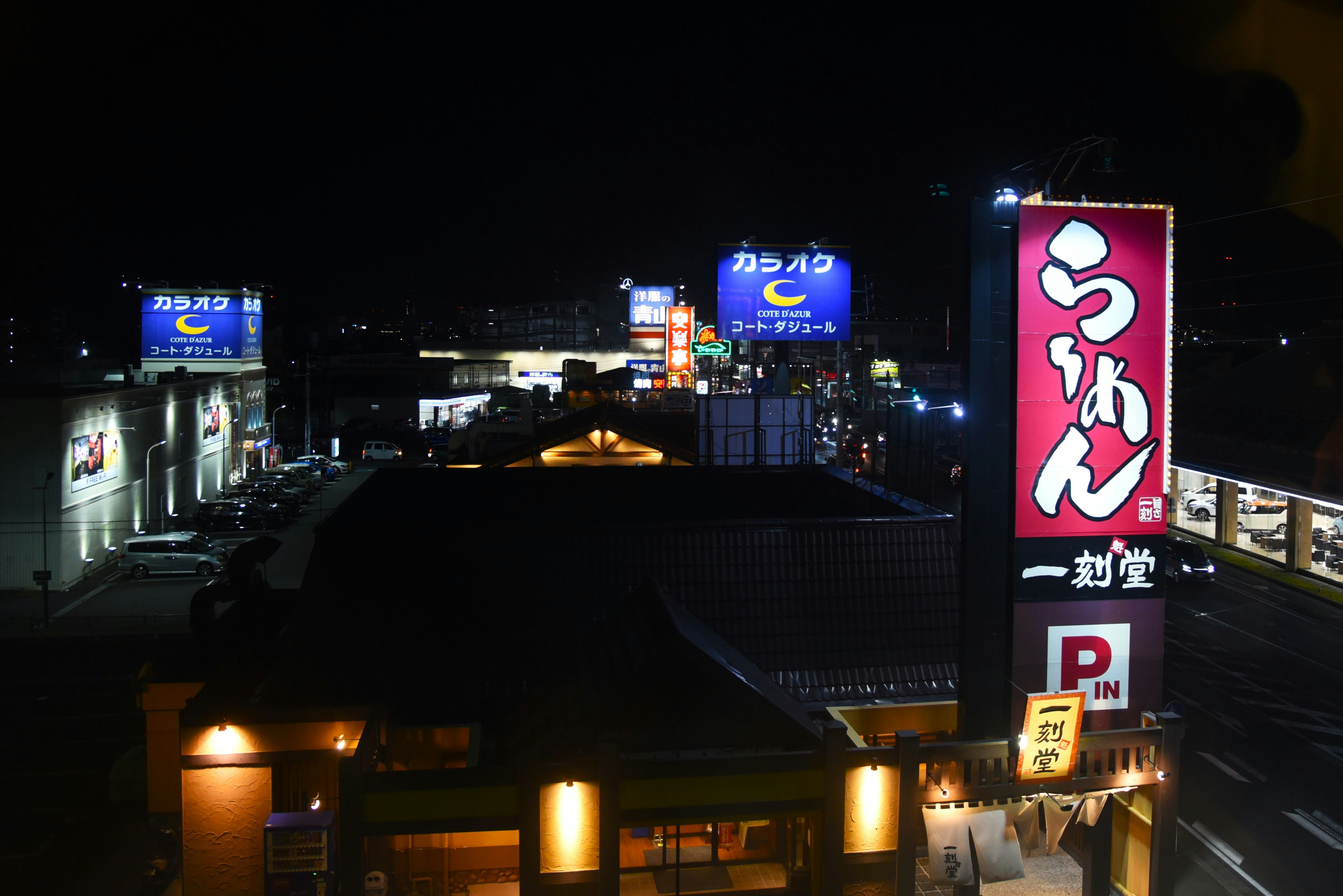 夜の看板が並ぶ商業施設の入口