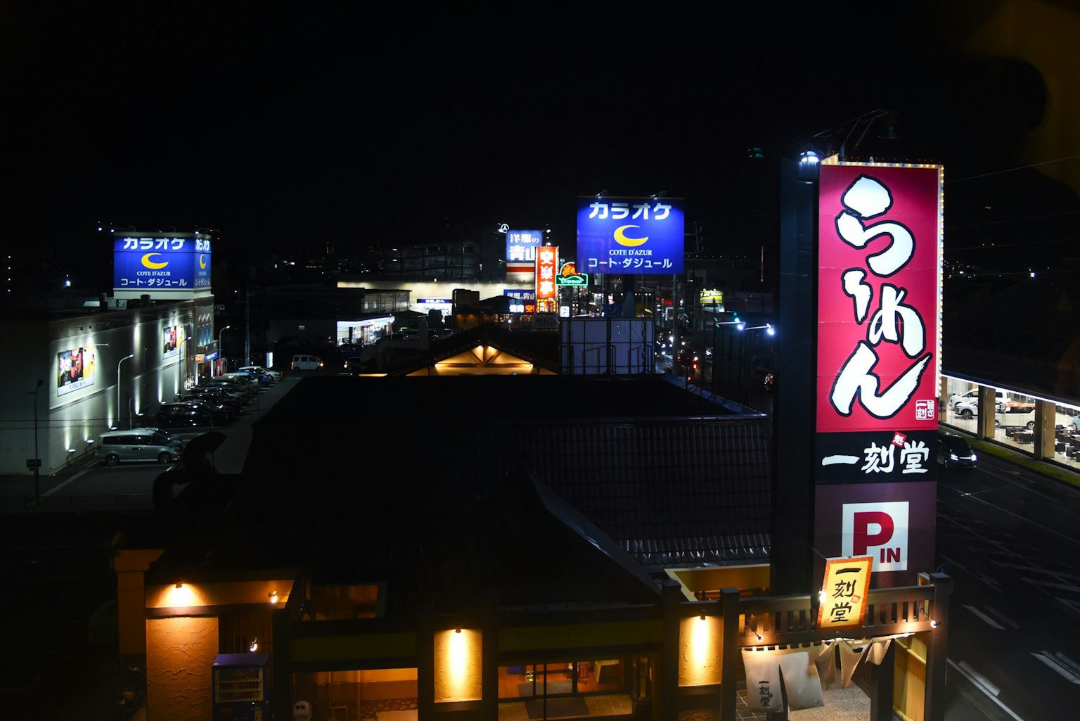 夜間城市景觀，特色拉麵店招牌和霓虹廣告