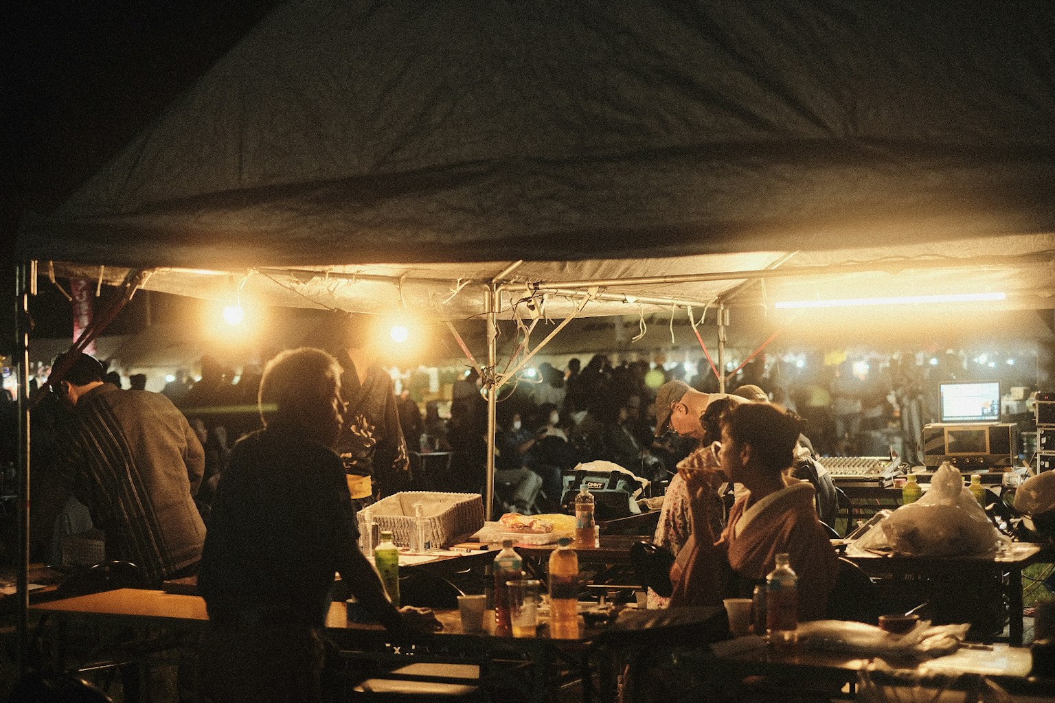 夜の屋台で人々が料理を楽しんでいる様子 照明が温かく雰囲気を演出