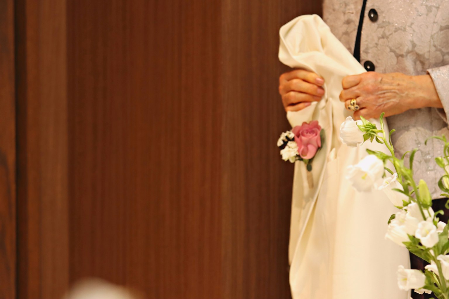 Woman holding a white fabric with flowers in her hand