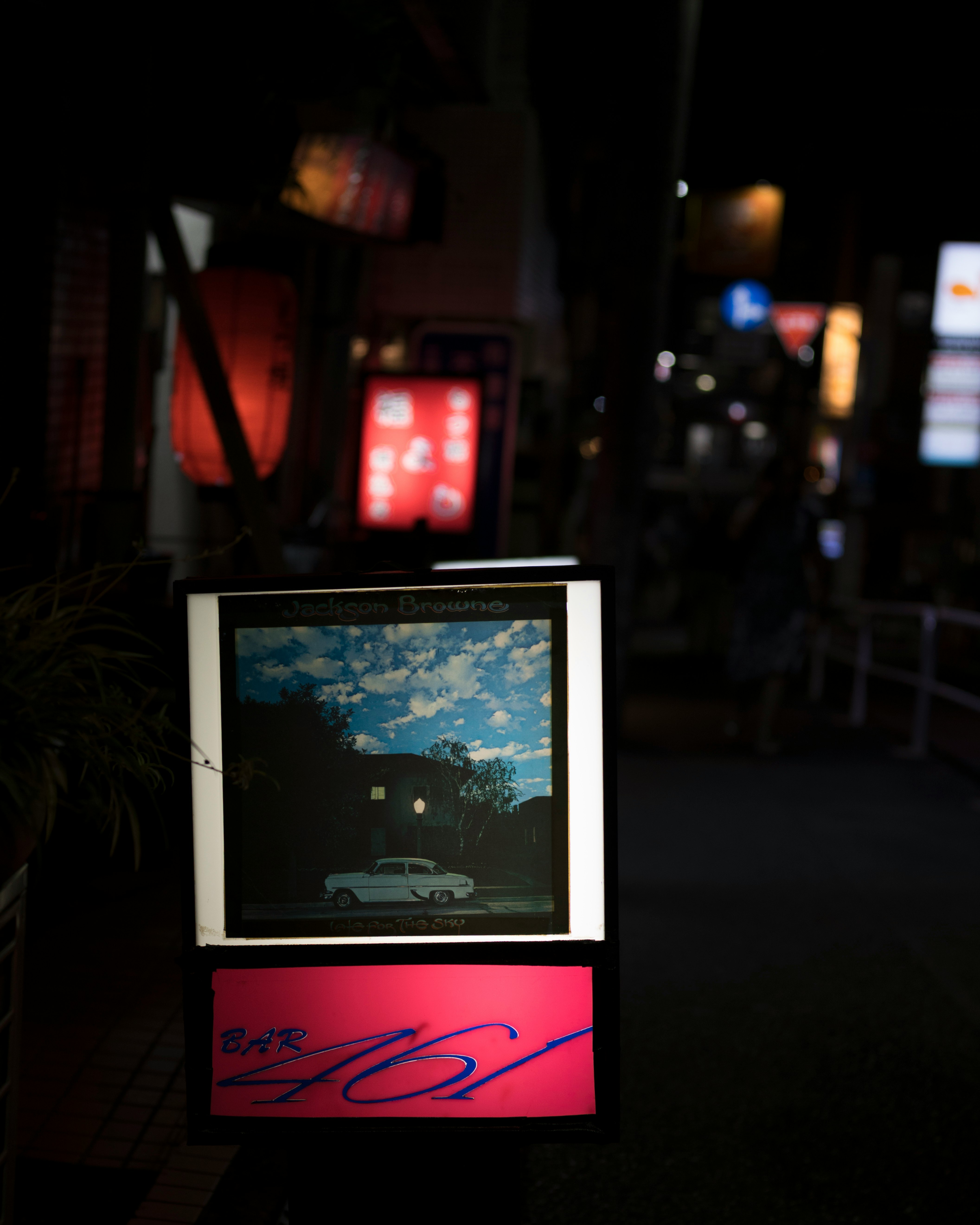 夜の街角に並ぶ看板とディスプレイのある展示スペース