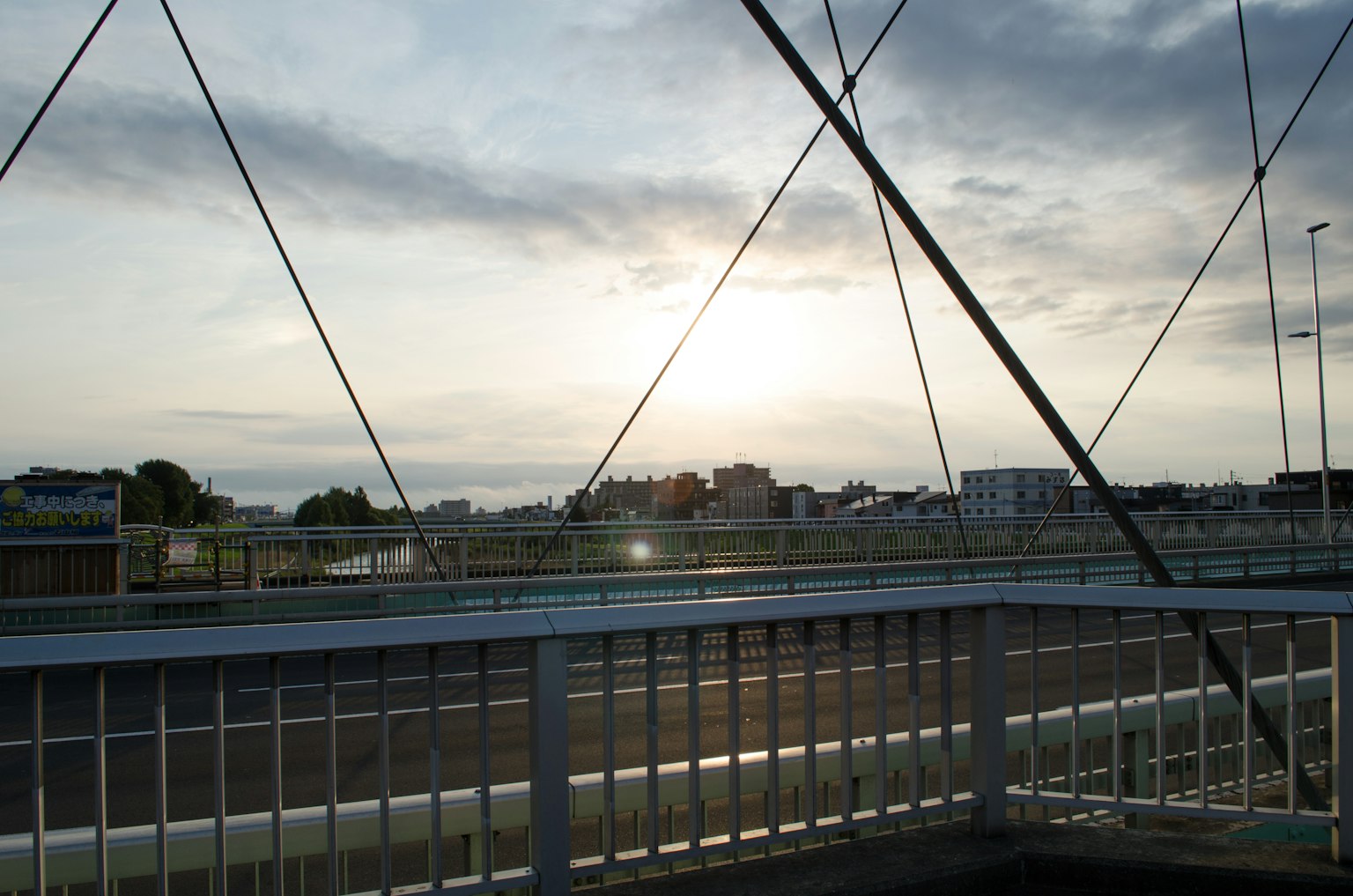 Vista de un atardecer sobre un puente con silueta de la ciudad
