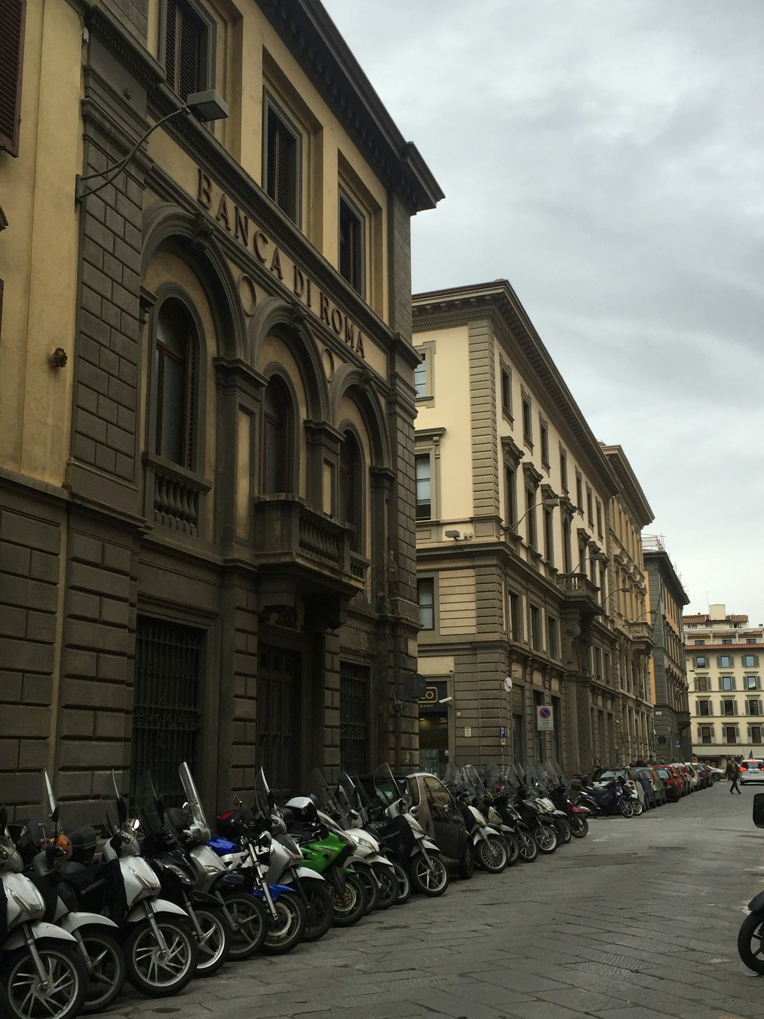 Historic buildings in Florence with parked scooters along the street