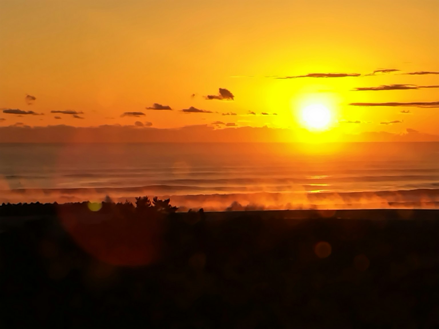 Un bellissimo tramonto sull'oceano con cielo arancione e onde calme