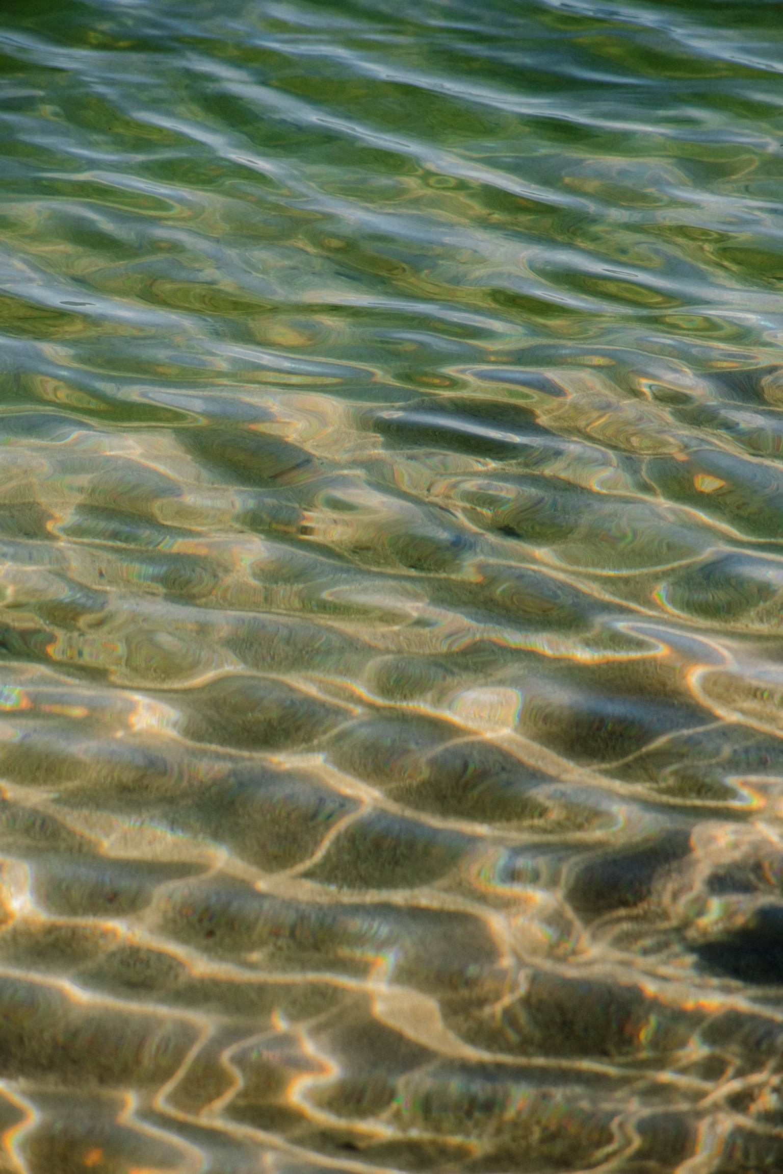 Superficie ondulata di acqua chiara che riflette la luce