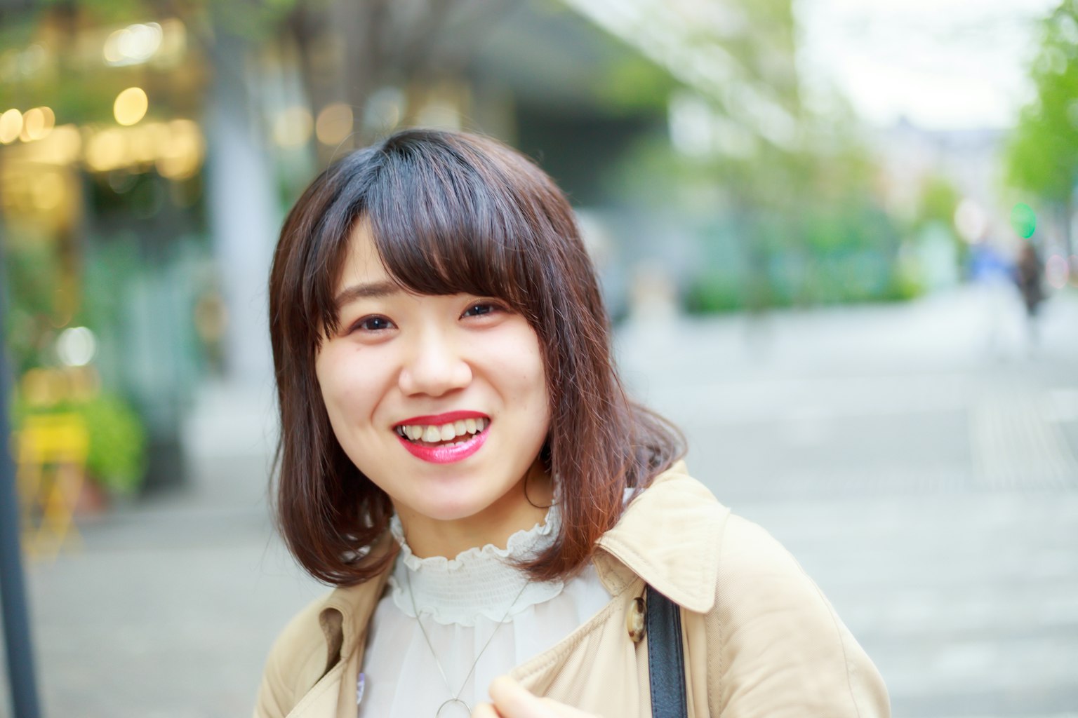 Smiling woman in casual clothing standing in an urban setting